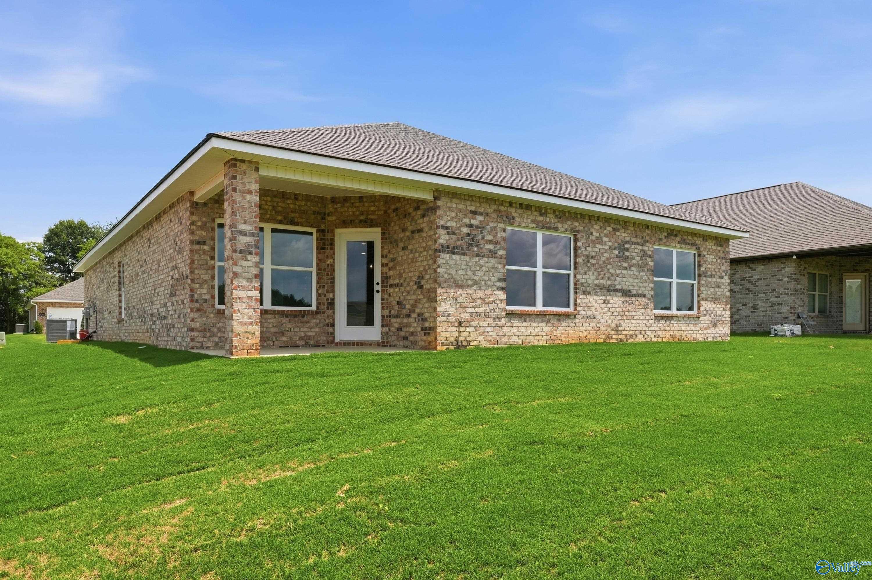 Brick exterior of The Daphne floor plan by Davidson Homes with a covered patio in Lynn Meadows, Meridianville, Alabama.