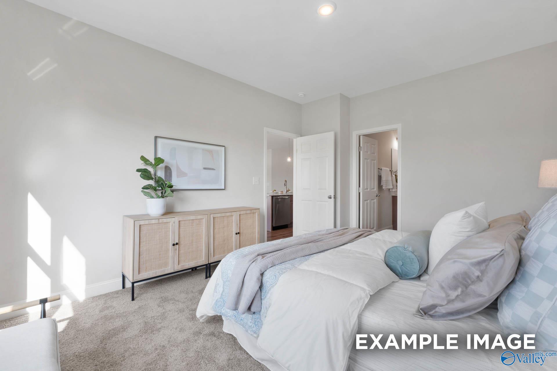 Bright, modern bedroom with neutral decor and en-suite bathroom in The Franklin C floor plan, Heritage Lakes, Alabama.