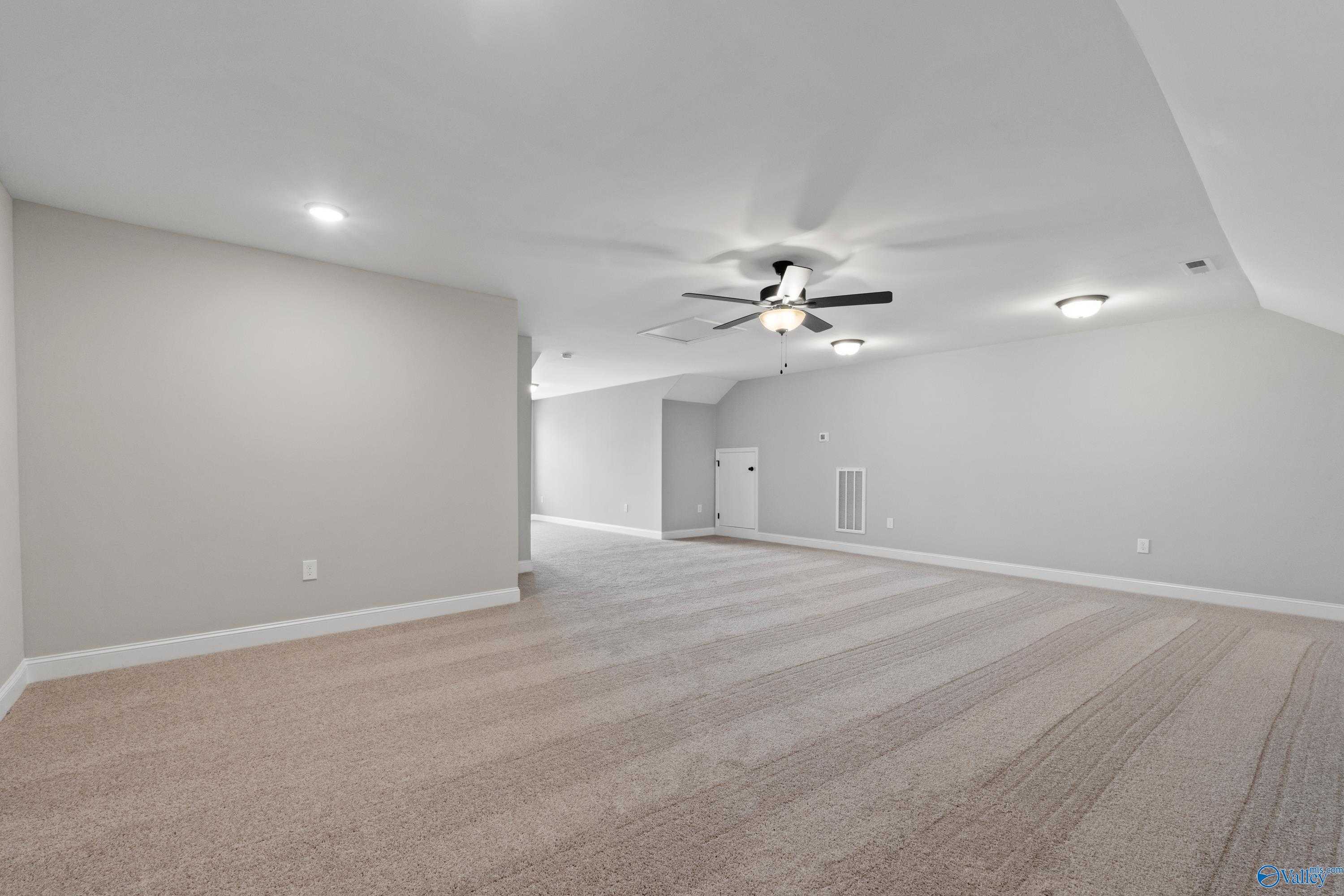 Spacious bonus room with beige carpet, gray walls, ceiling fan, and recessed lights in Davidson Homes The Rockford, Toney, AL