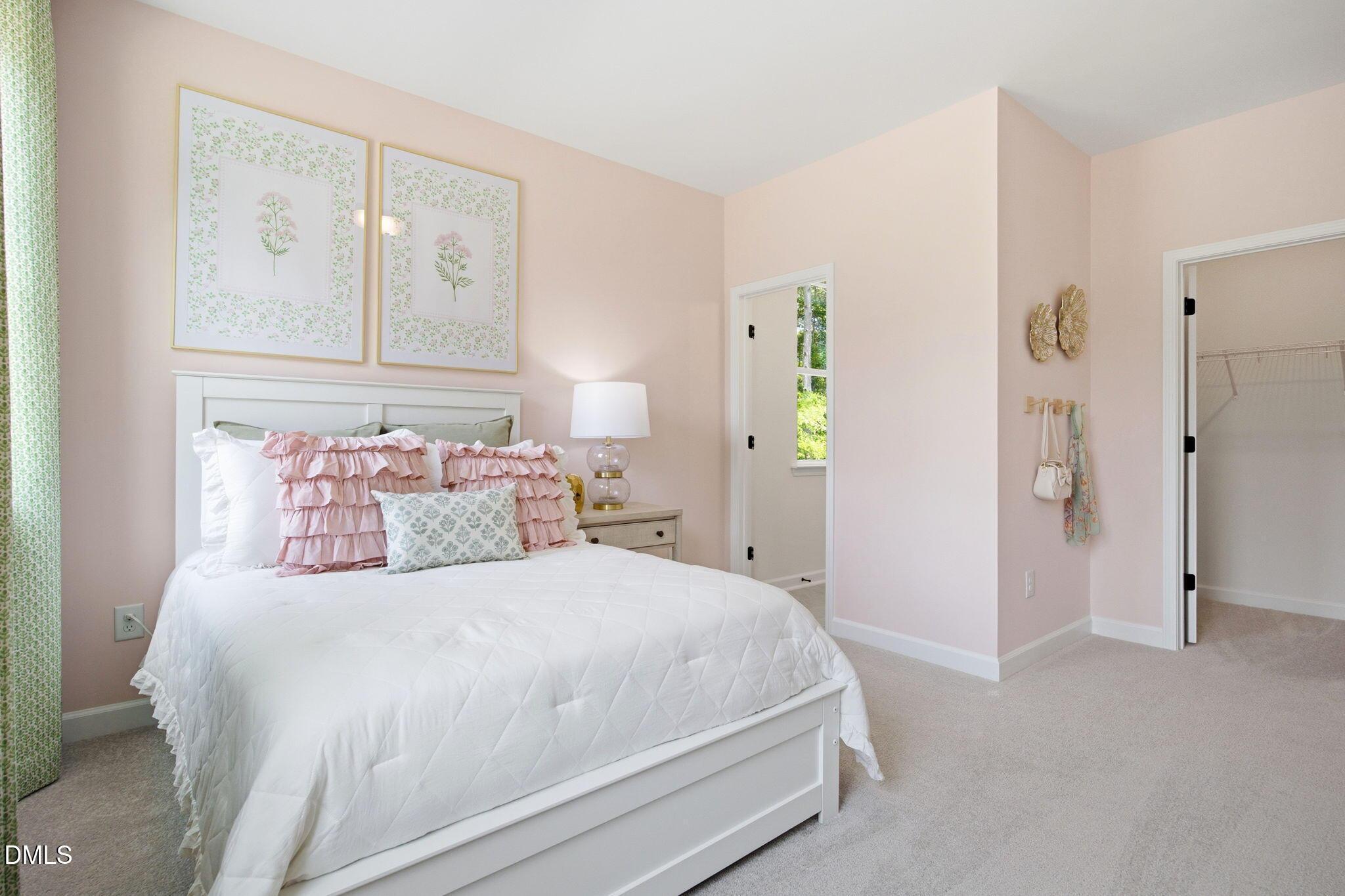 Cozy secondary bedroom with pink walls and walk-in closet in The Ashport M floor plan at Wendell Ridge, Wendell, NC.