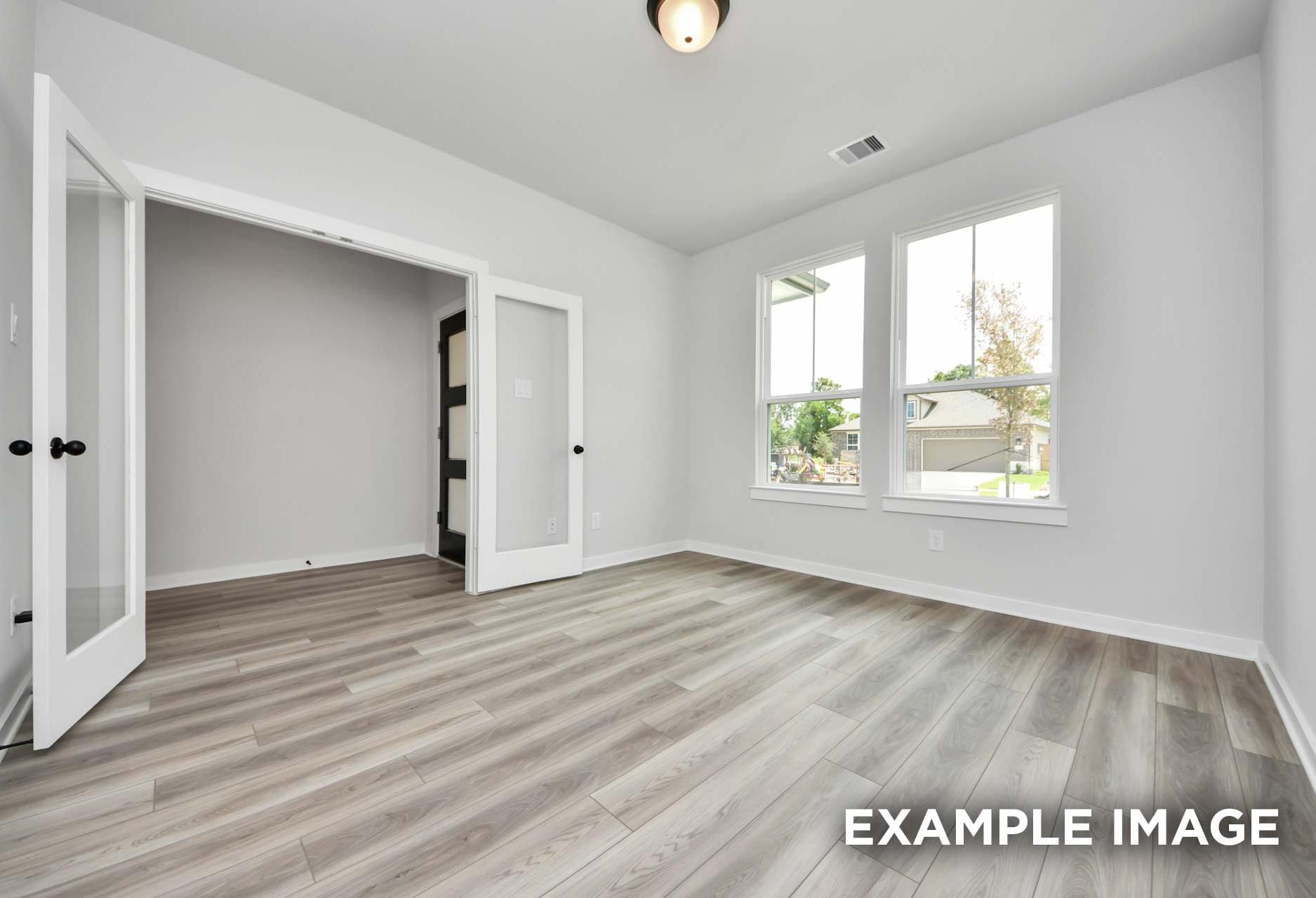 Bright flex room in The Sorrento home design featuring elegant French doors, light wood flooring, and large windows.