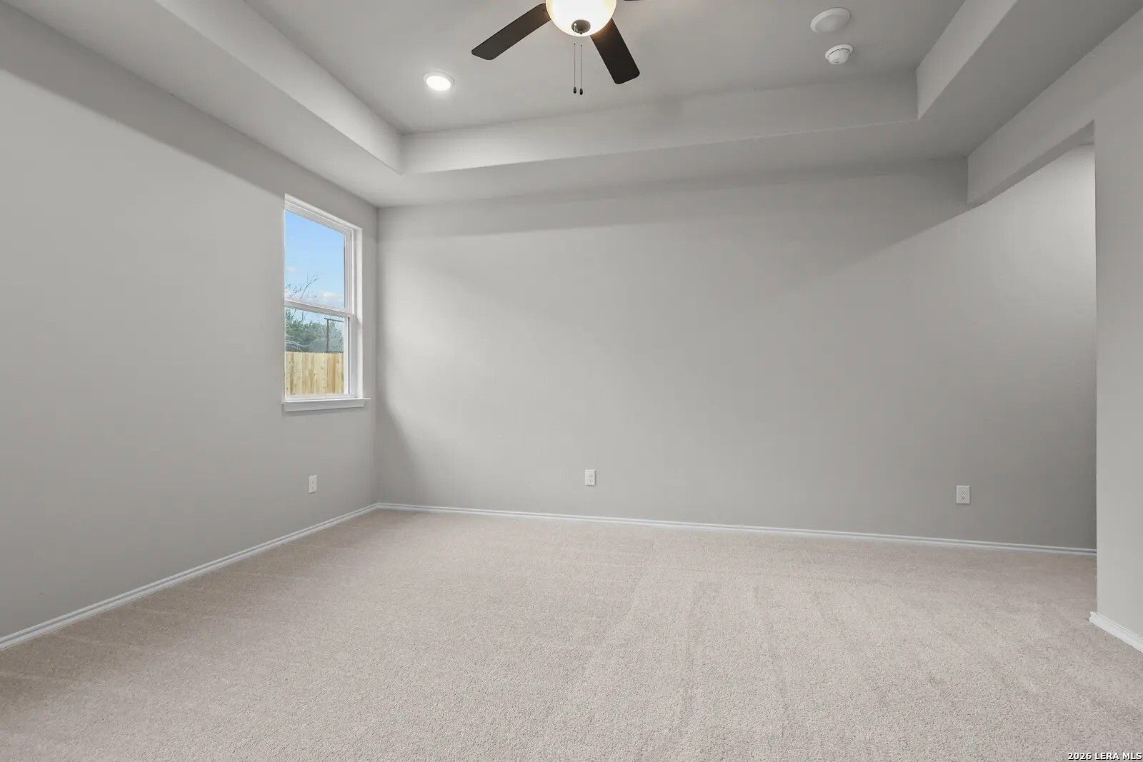 Spacious bedroom with tray ceiling and ceiling fan in The Glenwood E floor plan by Davidson Homes in San Antonio, Texas.
