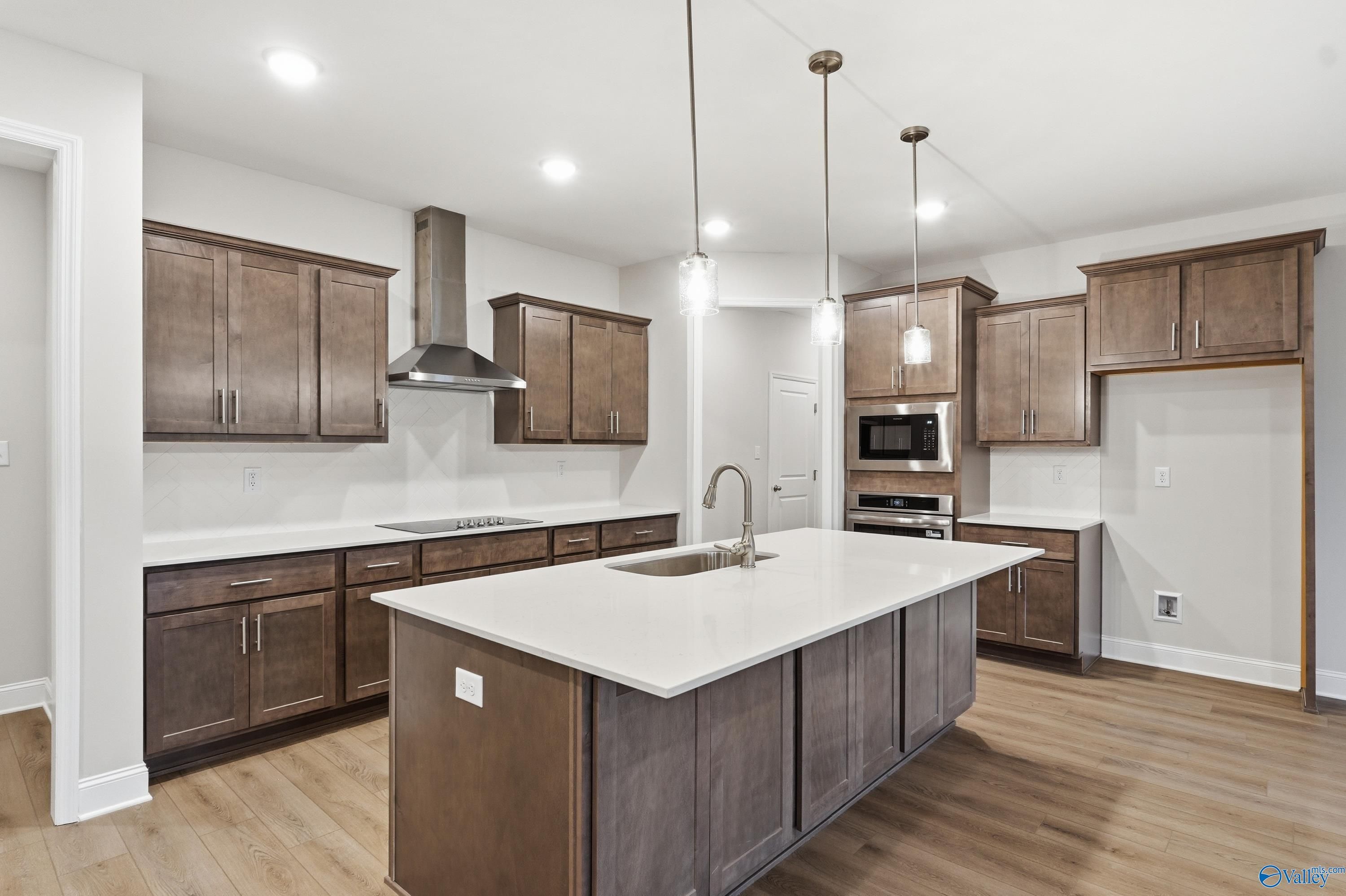 Modern kitchen with shaker wood cabinets, white quartz island, stainless appliances in Davidson Homes The Kirkland, Decatur AL