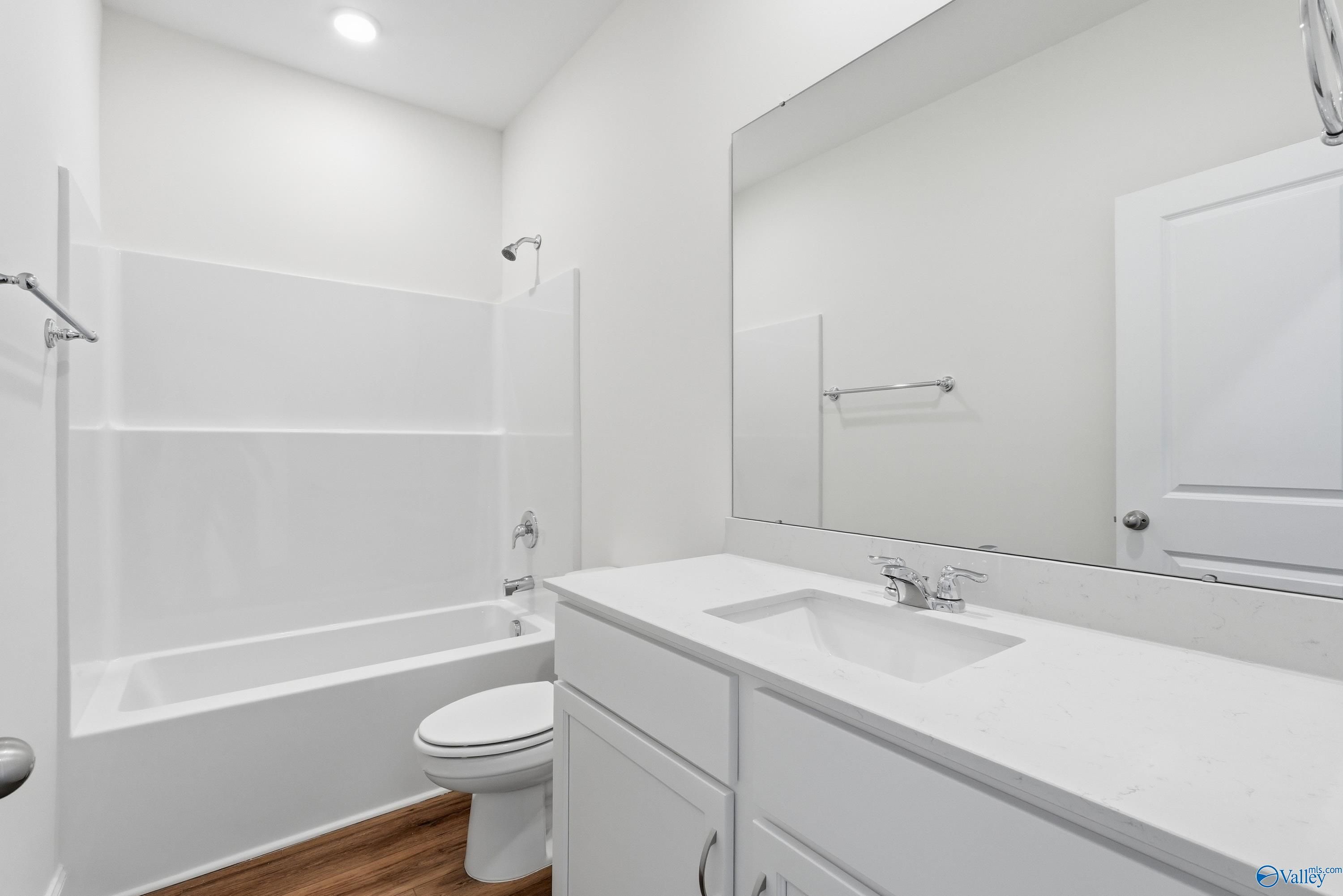 Modern bathroom with white vanity, quartz countertop, and tub-shower combo in The Asheville home, Jaguar Hills, Huntsville.