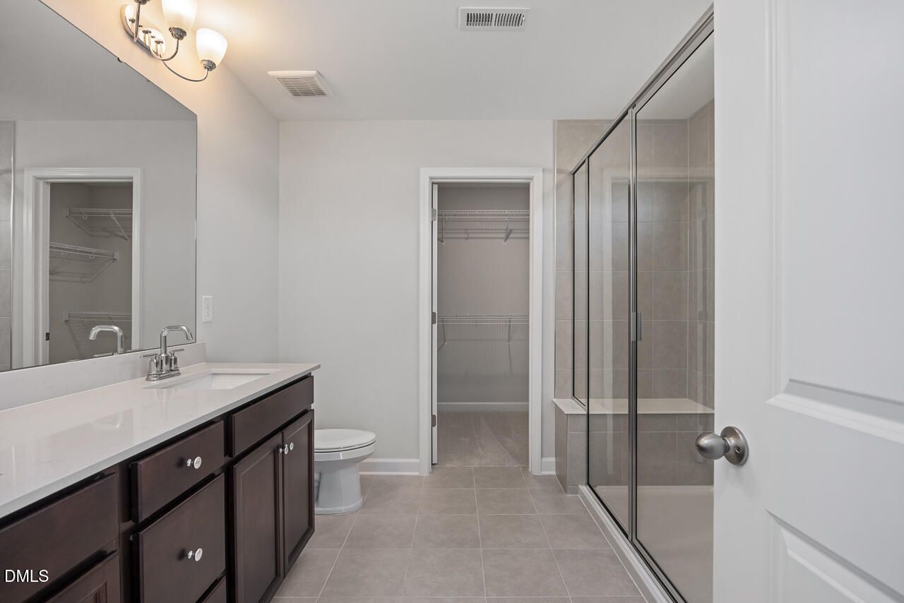 Modern primary bathroom with walk-in shower and vanity in The Grace C floor plan at Retreat at North Main, Lillington, NC.