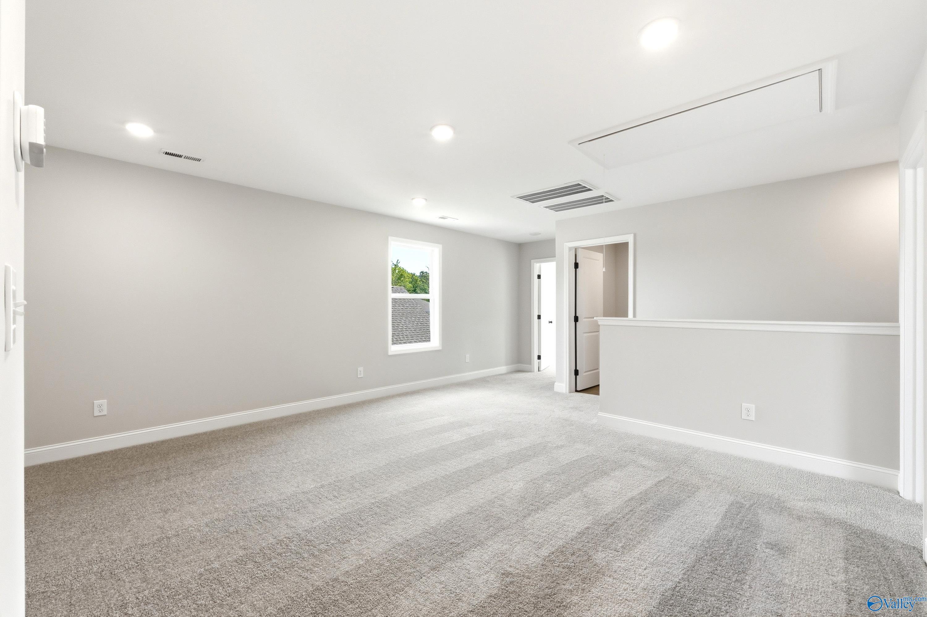Spacious carpeted bonus room with recessed lighting in The Russell A floor plan by Davidson Homes in Huntsville, Alabama.