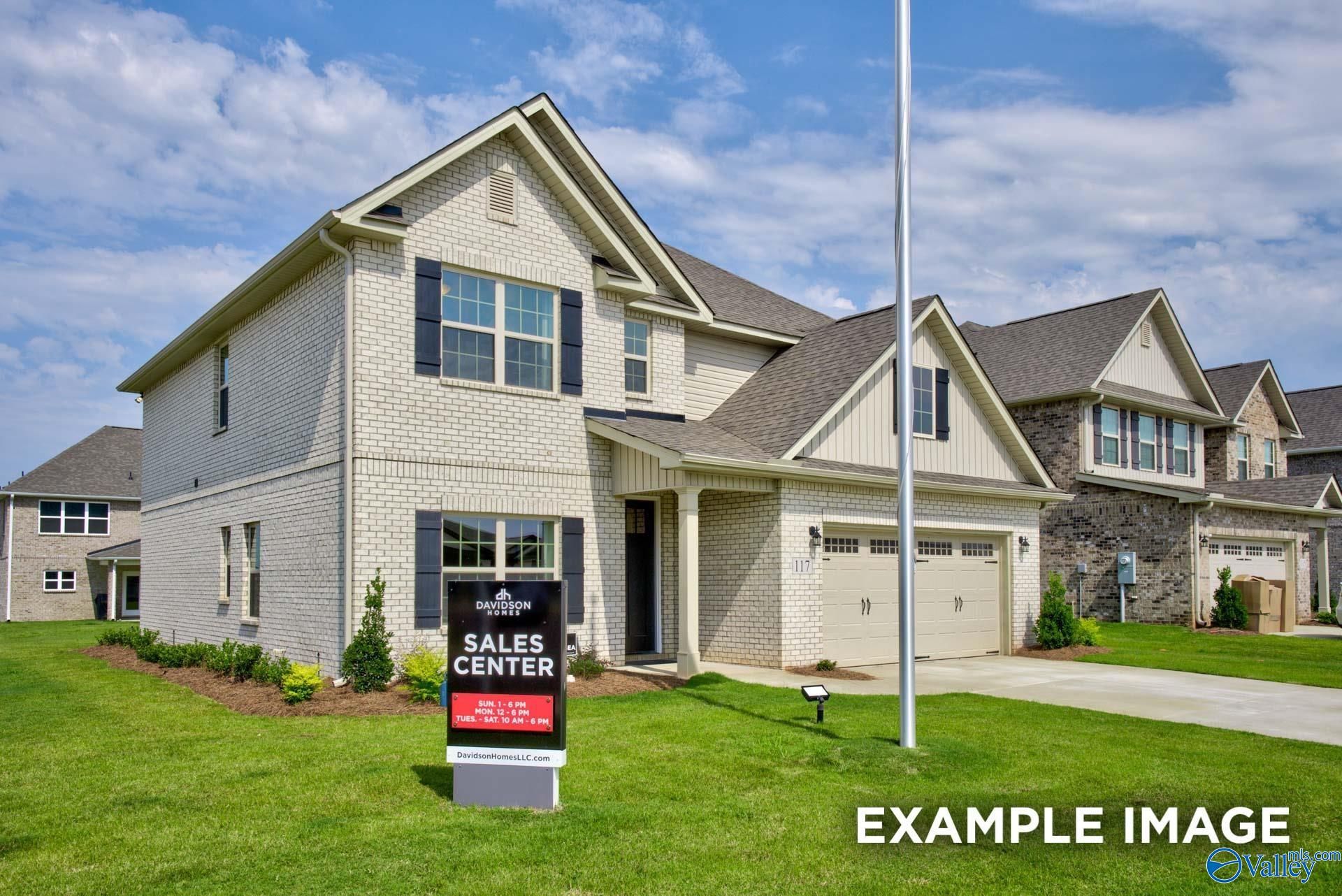 Two-story white brick exterior with 2-car garage and Davidson Homes sales center sign at Ivy Hills in Toney, Alabama