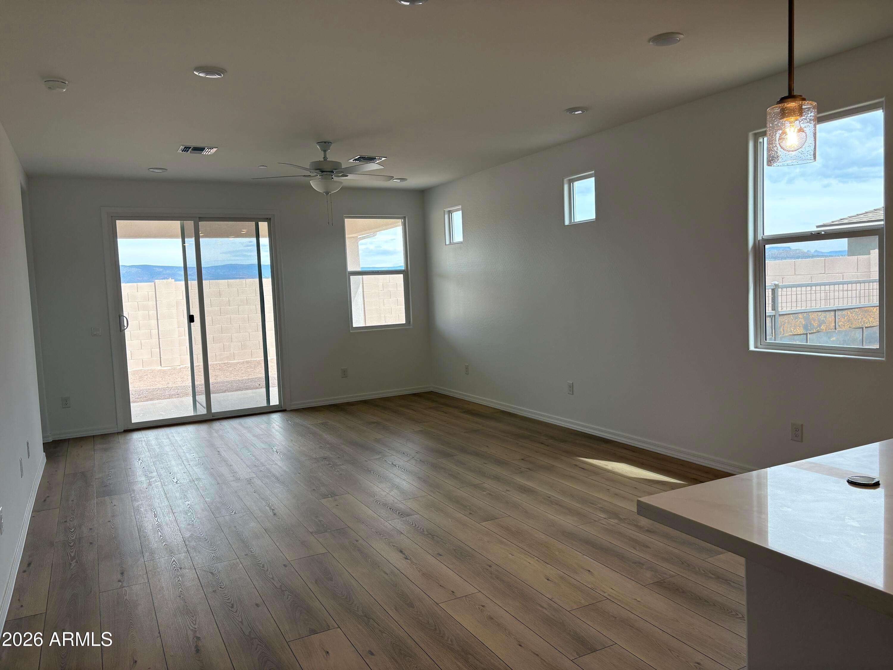 Bright open-concept living room with wood-look flooring and mountain views in The Evergreen B by Davidson Homes, Cottonwood, AZ
