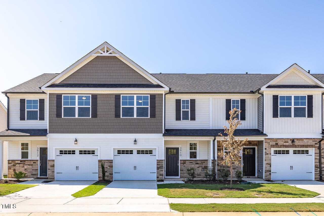 Modern two-story townhome with gray siding, brick accents, double garage, and front porch in Springvale, Fuquay-Varina, NC by Davidson Homes The Warren