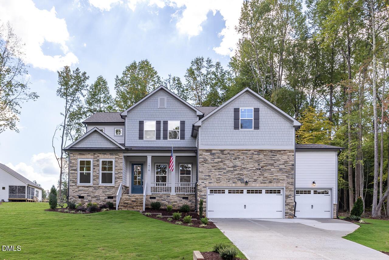 Two-story stone and shingle exterior with front porch and 3-car garage in Davidson Homes Crawford D plan, Wake Forest, NC