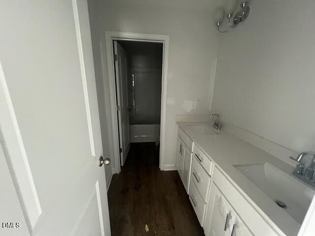 Modern bathroom with double vanity, quartz countertops, and tub-shower combo in The Ash B floor plan, Retreat at North Main.