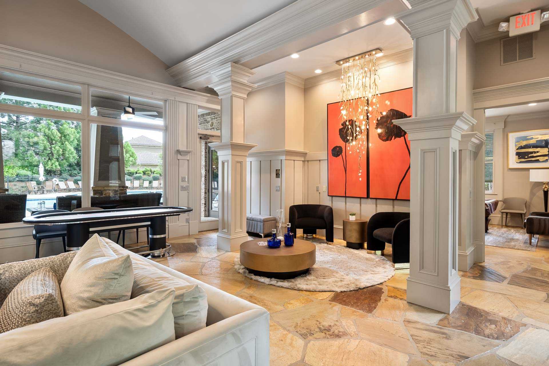 Elegant lounge at The Village at Towne Lake Woodstock GA featuring grand piano, orange abstract art, white sofa, and pool view