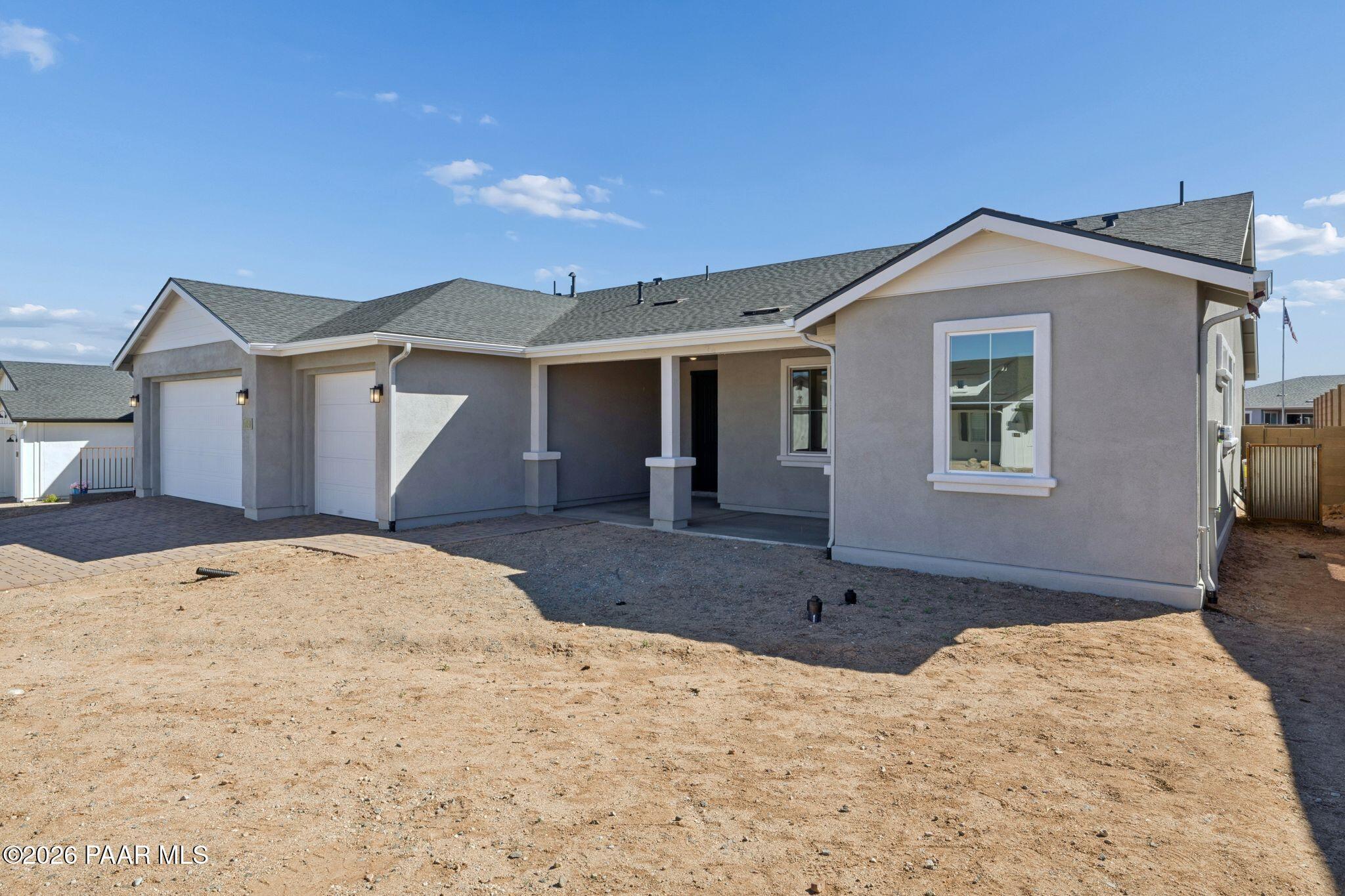 Modern beige stucco single-story home with 3-car garage and covered entry in Westwood, Prescott, Arizona by Davidson Homes