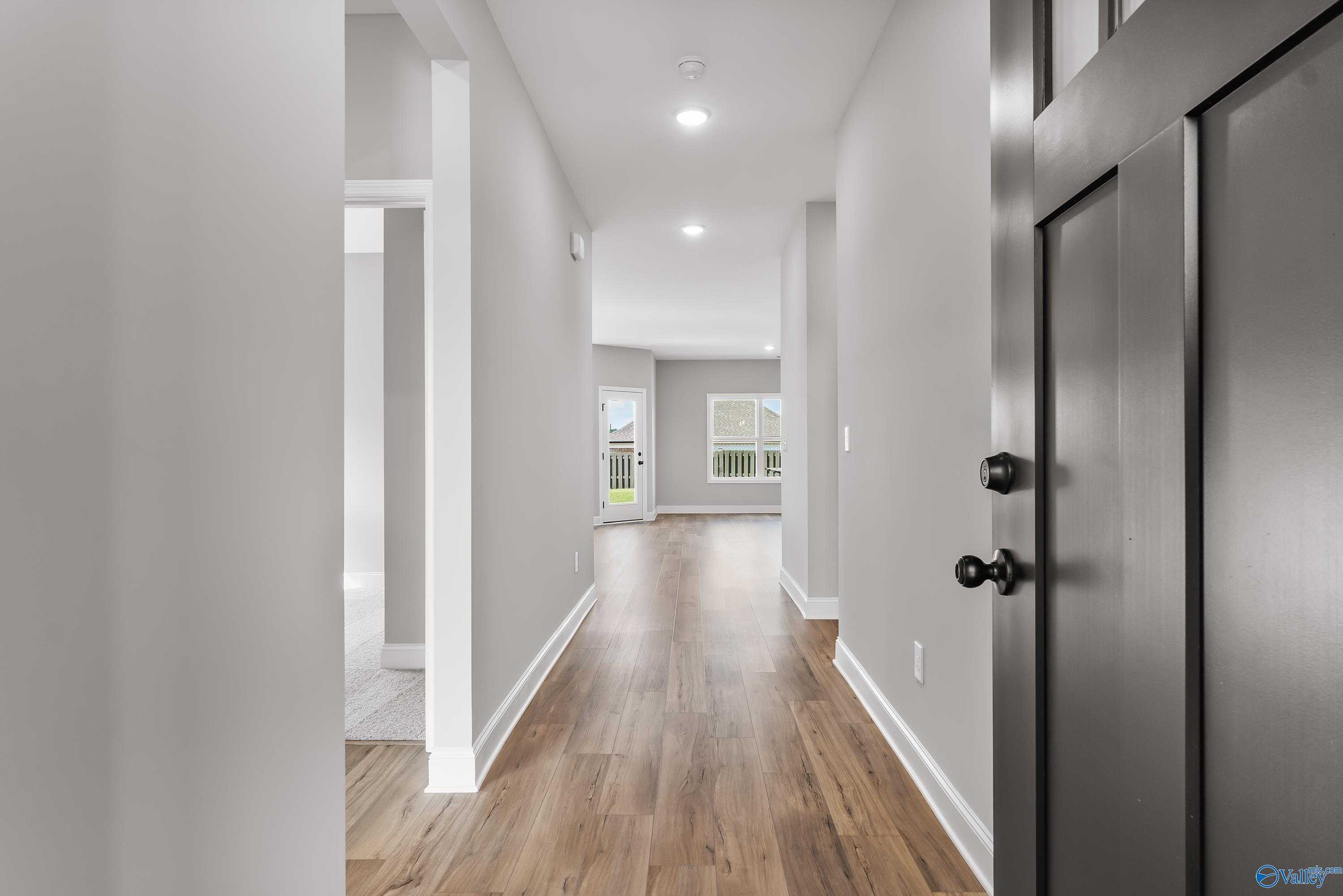 Wide hallway with hardwood floors and neutral gray walls in Davidson Homes The Franklin B, Hazel Green, Alabama