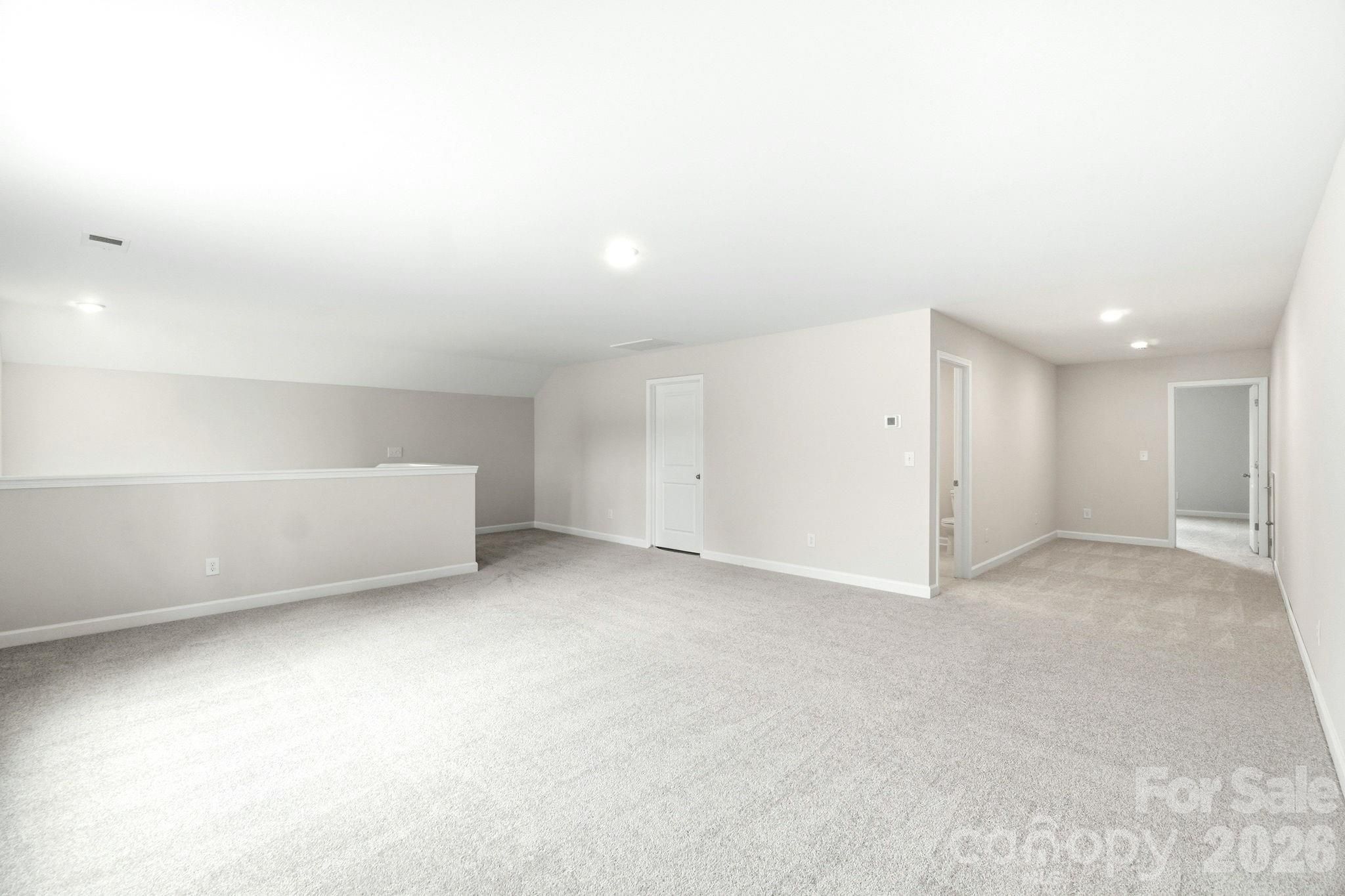 Spacious carpeted bonus room in The Magnolia B floor plan by Davidson Homes in Windgate, Mooresville, North Carolina.