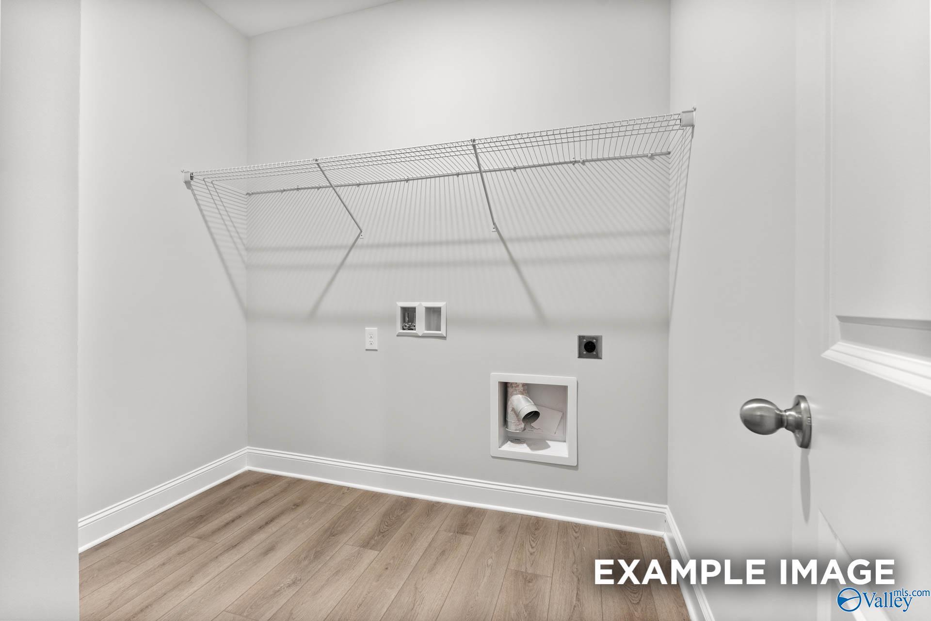 Spacious laundry room with wire shelving, washer dryer hookups, and laminate flooring in Davidson Homes The Daphne, Meridianville, Alabama