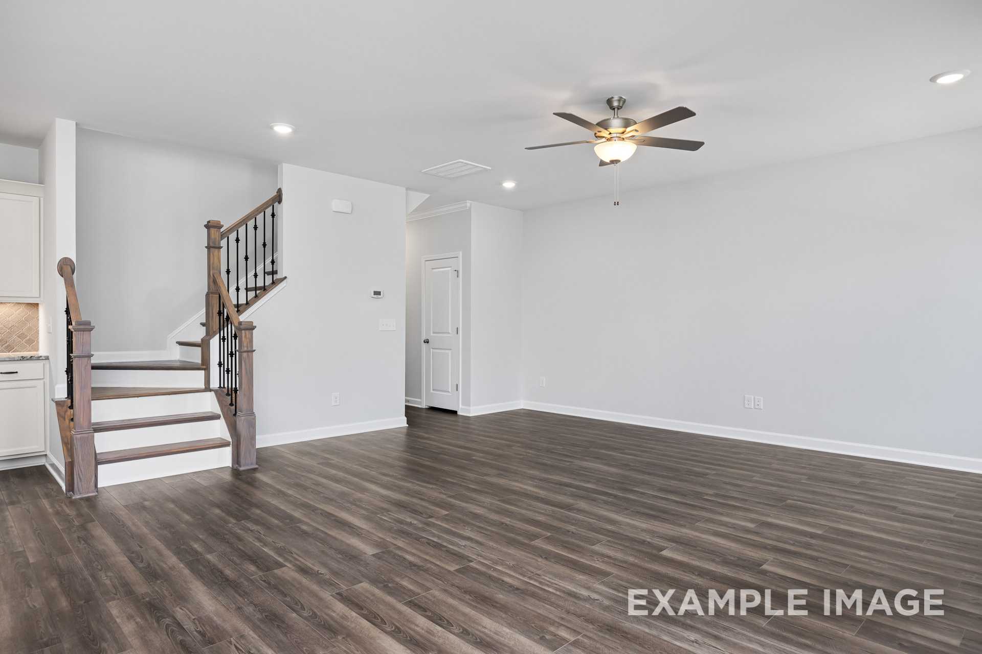 Spacious two-story foyer in The Grace C home design featuring wooden staircase, open living area, hardwood floors, and ceiling fans