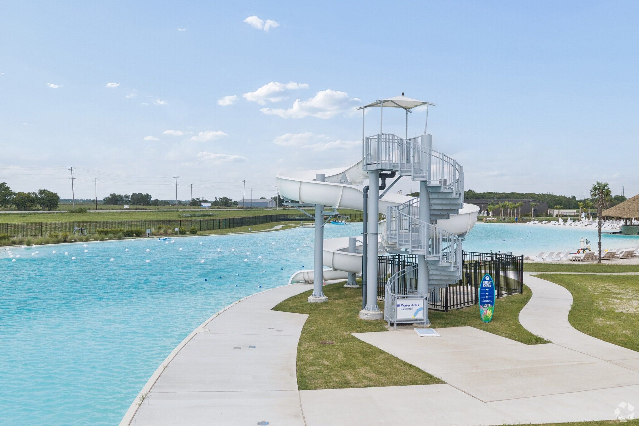 White water slide tower at turquoise lagoon pool in River Ranch Meadows, Dayton, Texas by Davidson Homes community amenities