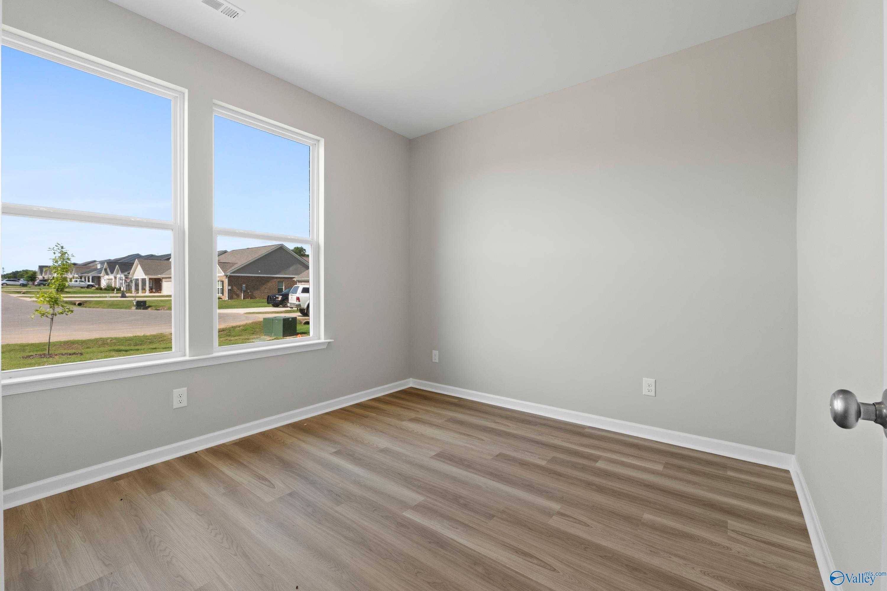 Bright secondary bedroom with large windows overlooking neighborhood, hardwood floors in Davidson Homes The Polaris, Fayetteville, TN