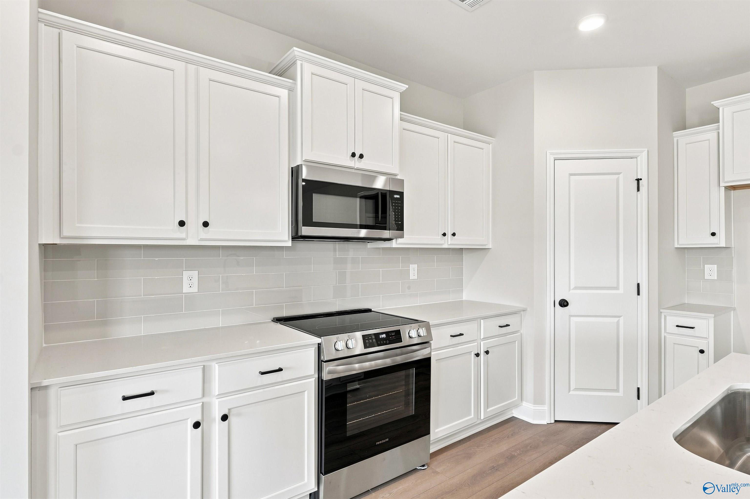 Bright kitchen with white shaker cabinets, subway tile backsplash, and stainless appliances in Davidson Homes Everett B, Toney, AL