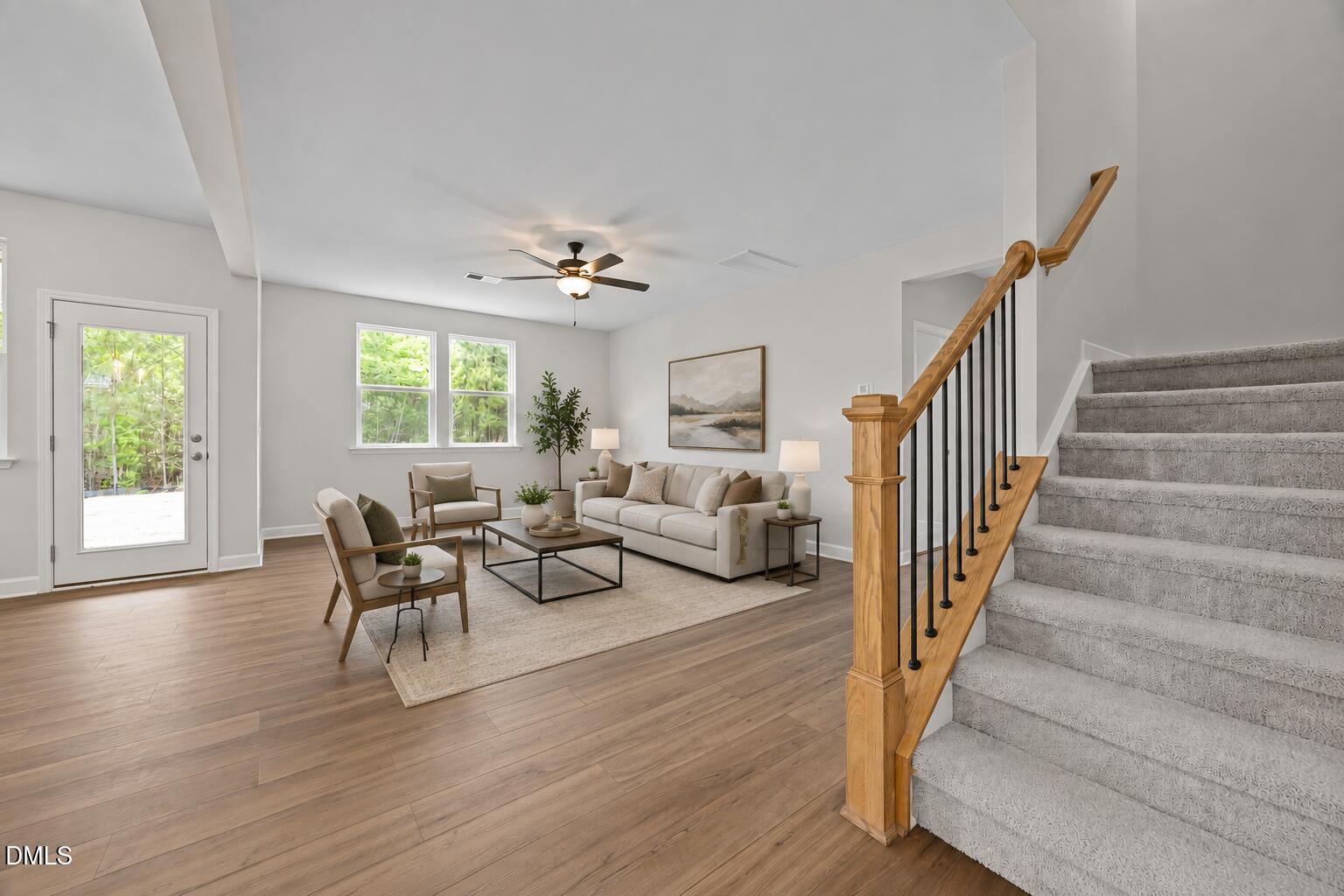 Bright, open-concept living room with wood-style flooring and staircase in Davidson Homes' Willow D plan at Wendell Ridge.