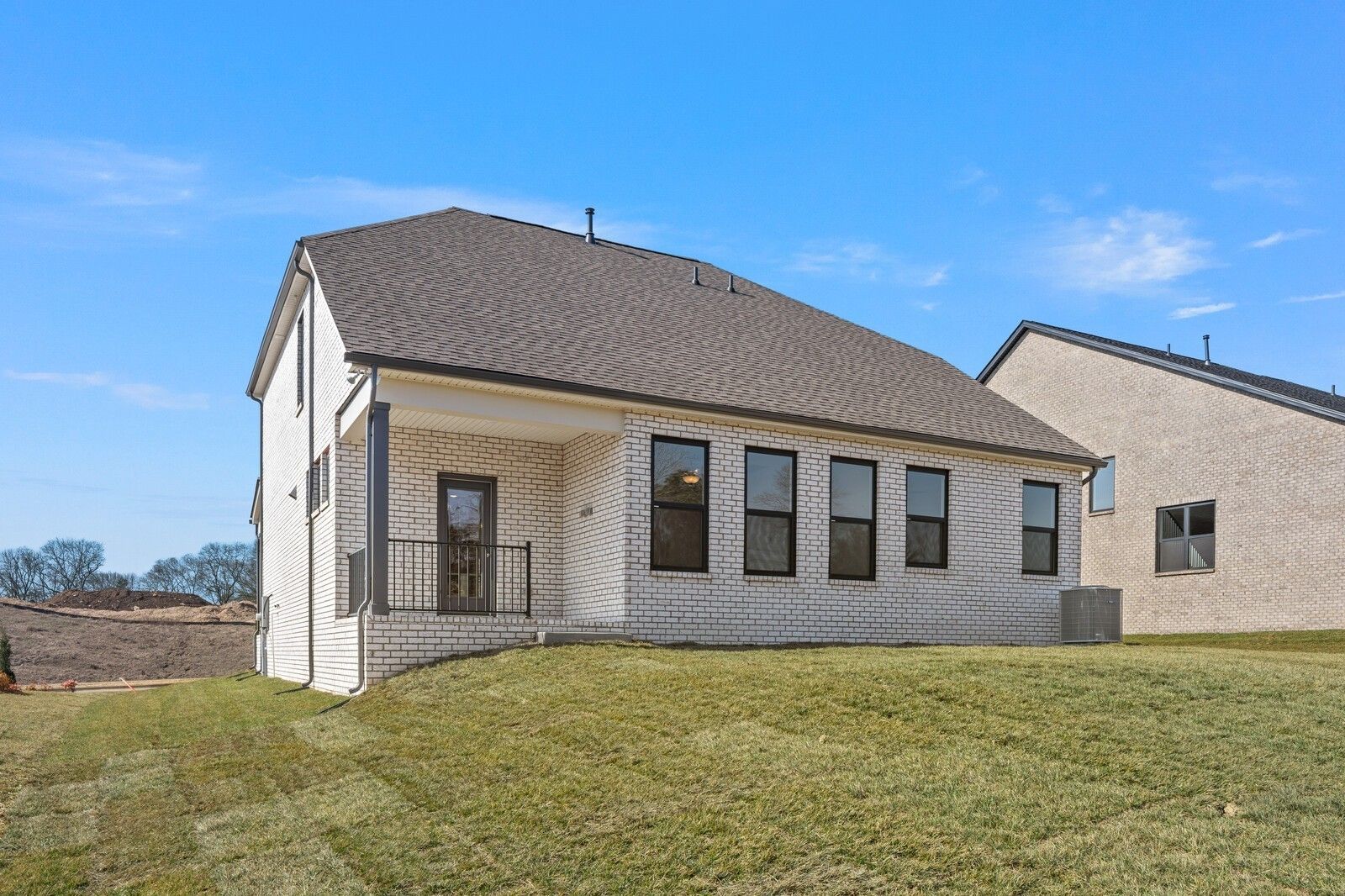 Two-story white brick Ash C home with covered porch, large windows, and green lawn in Benders Cove, Mt. Juliet