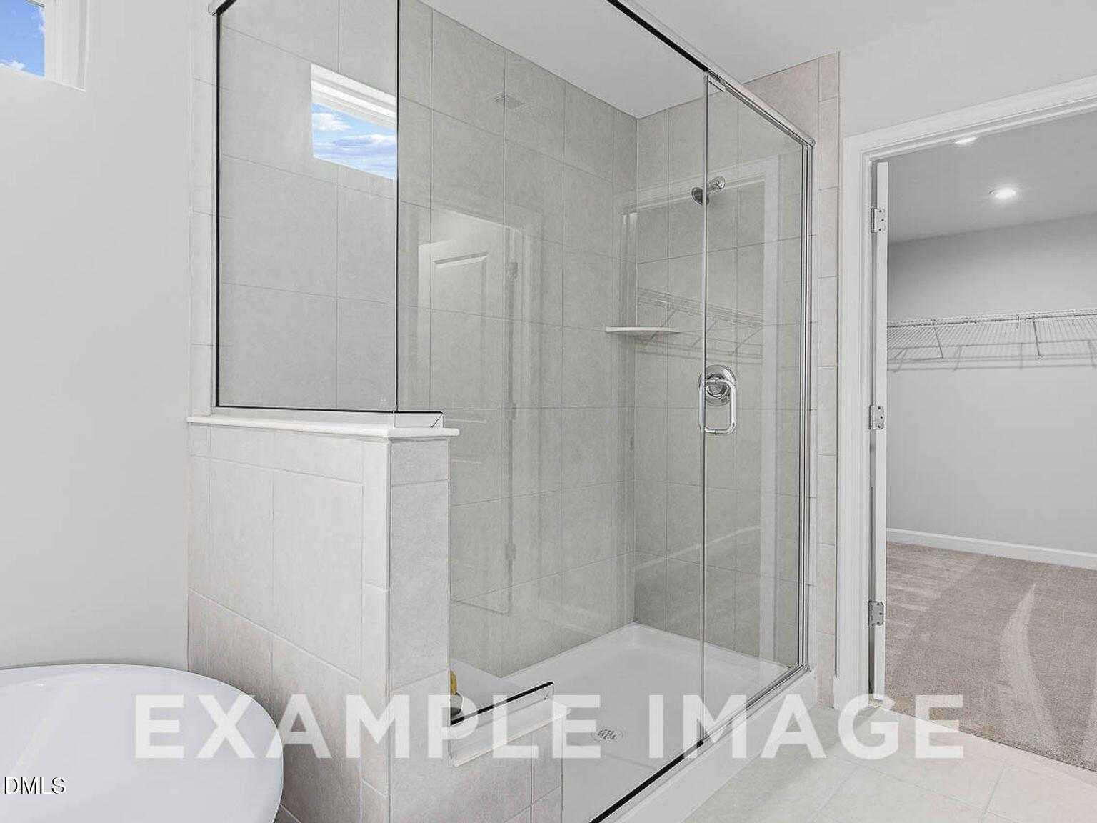 Modern master bathroom with frameless glass shower, white subway tiles, and vessel sink in The Chestnut B by Davidson Homes, Lillington, NC