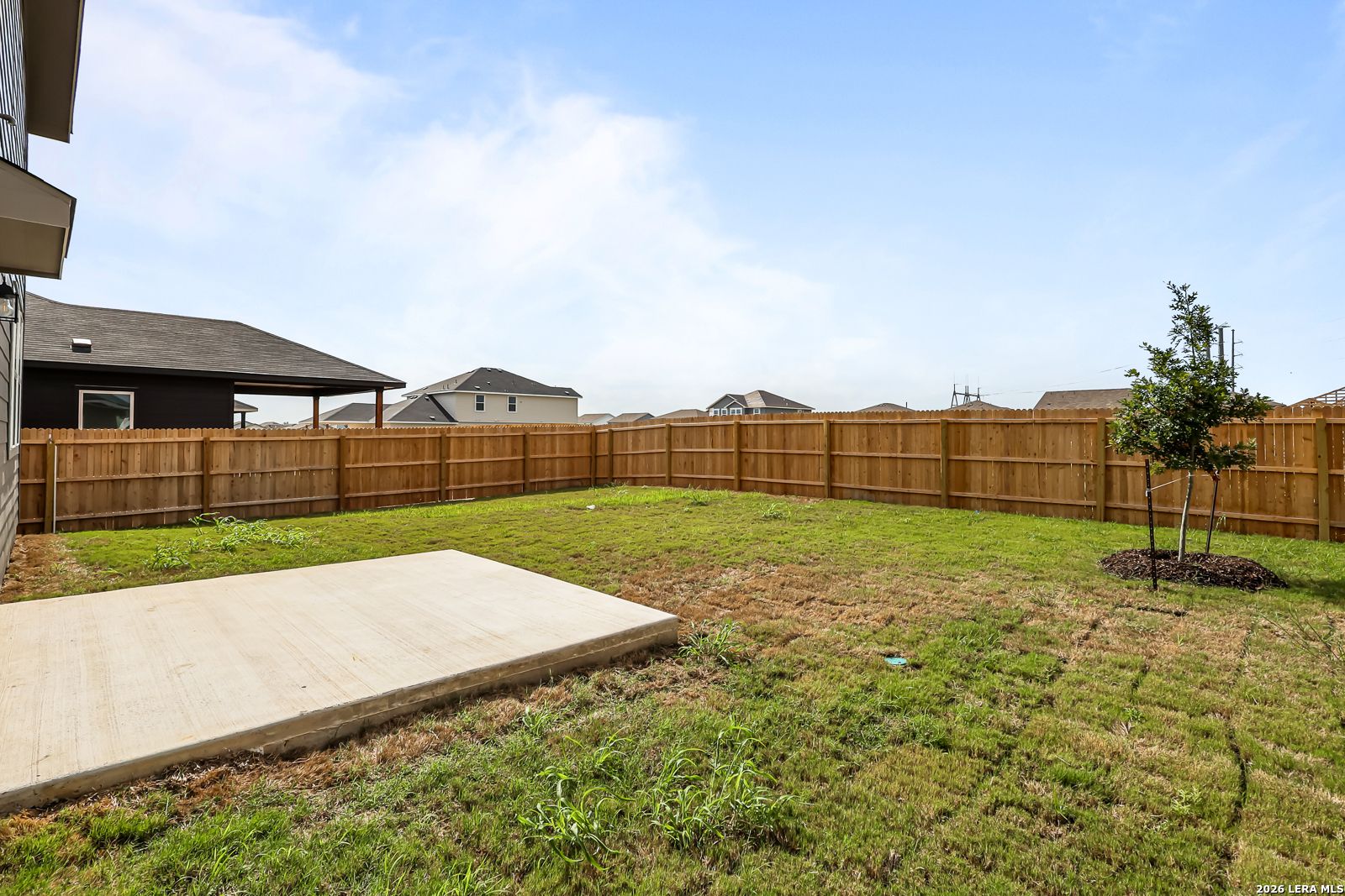 Private backyard with concrete patio and wood privacy fence at a Davidson Homes property in Hannah Heights, Seguin, Texas.