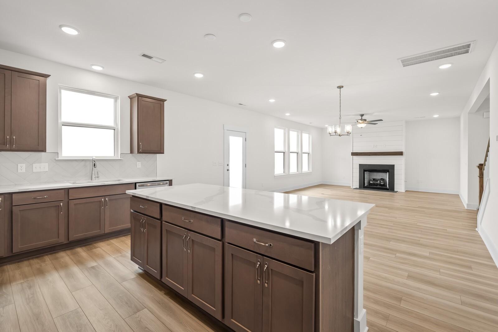 Open-concept kitchen with large island and living room fireplace in The Henry C floor plan, Benders Cove, Mt. Juliet, TN.
