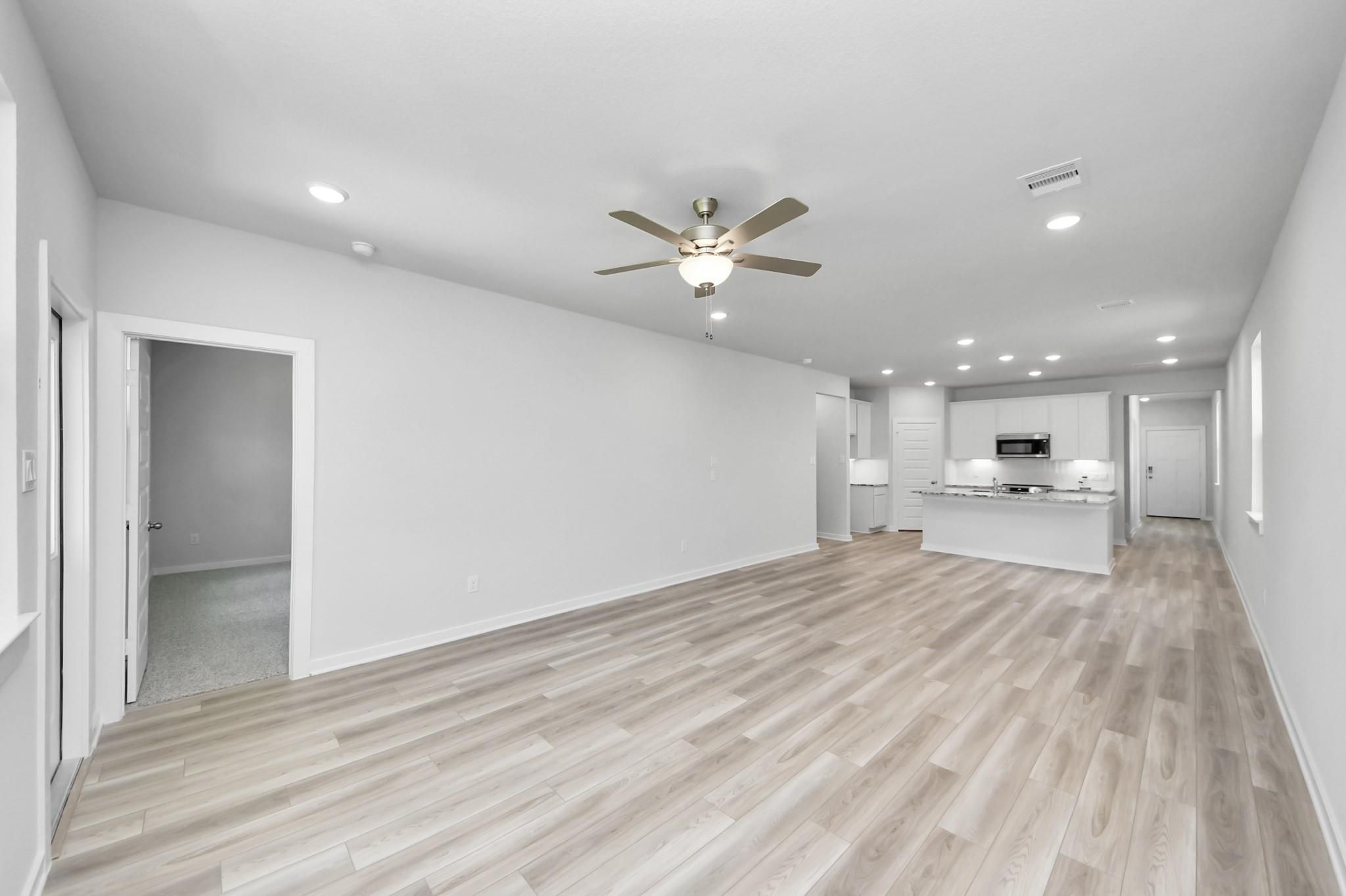Open-concept living room and kitchen in The Sabine F floor plan at Liberty Estates, Cleveland, Texas.