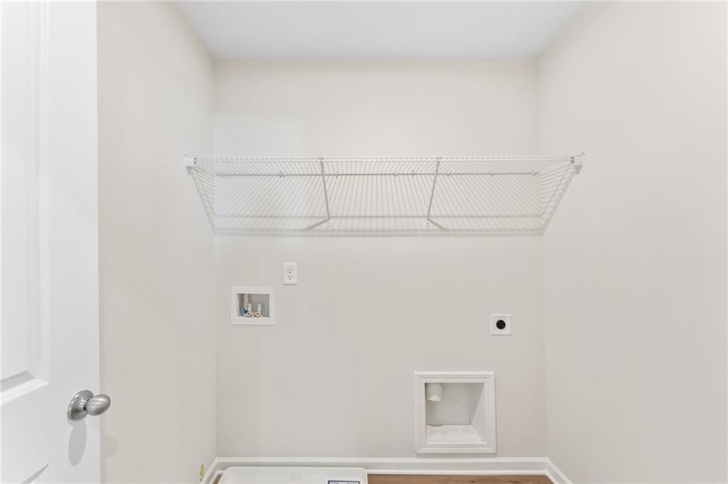 Bright laundry room with wire shelving and washer-dryer hookups in 4-bedroom The Willow B home, Davidson Homes, Riverwood, Dallas, Georgia