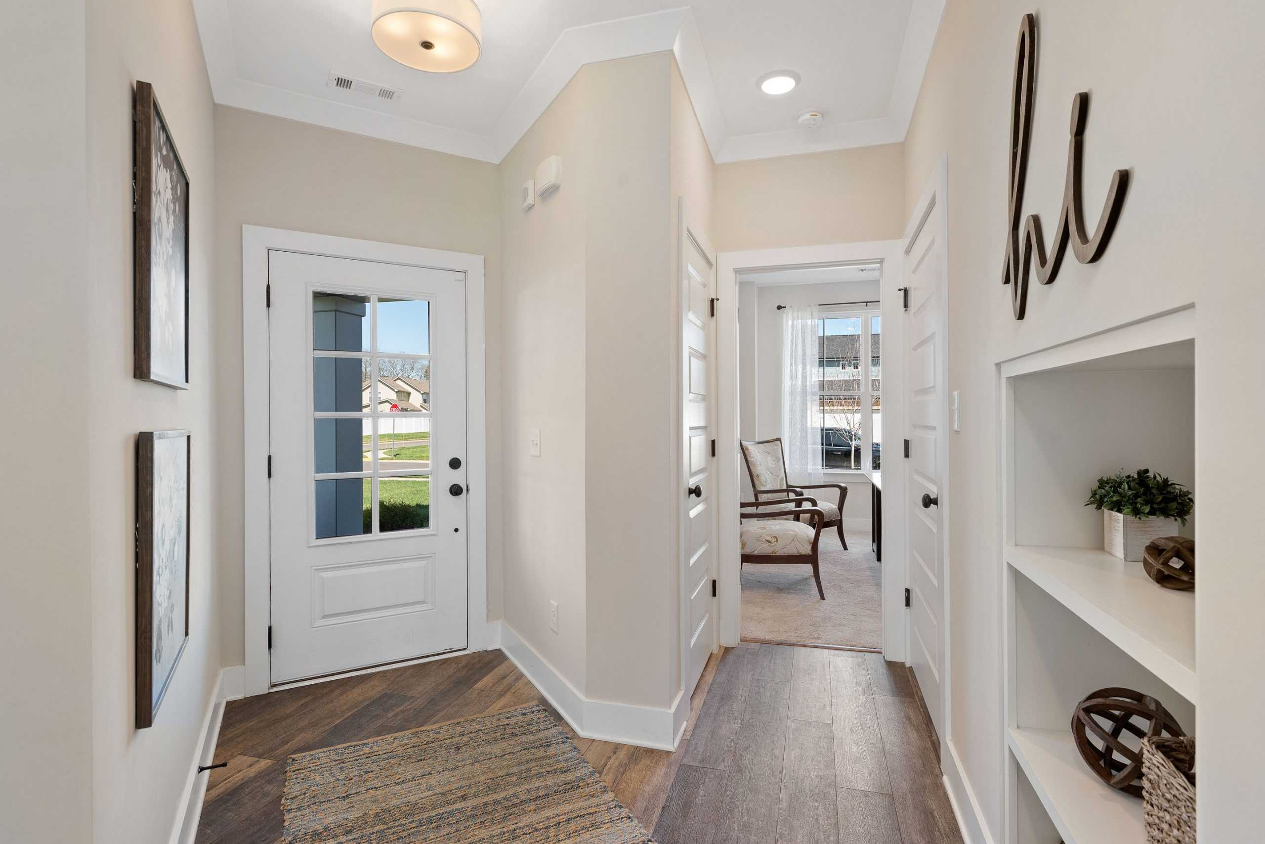 Spacious entryway hallway at Rivers Edge in Murfreesboro TN with light hardwood floors, white doors, and built-in shelving