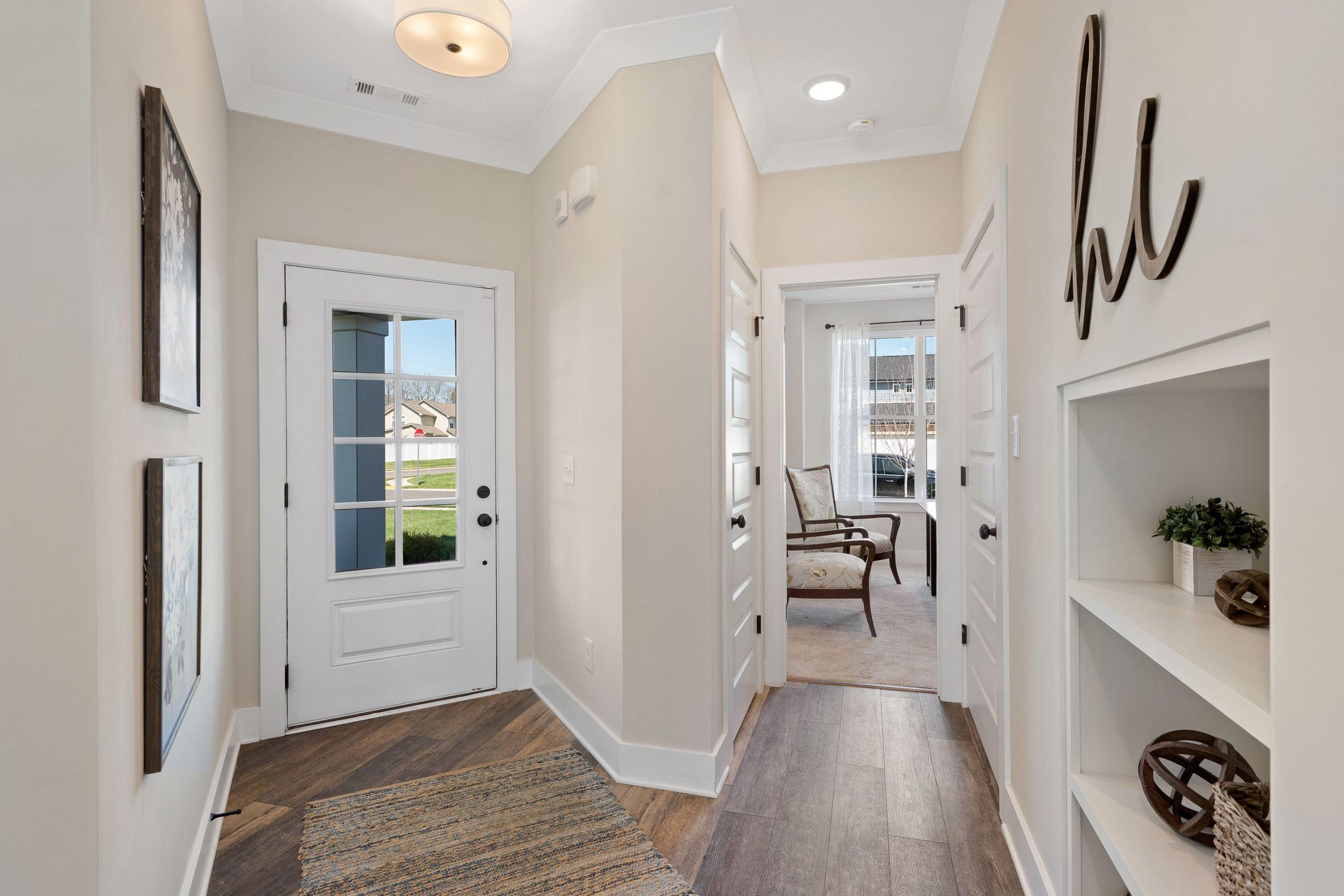 Spacious entryway hallway at Rivers Edge in Murfreesboro TN with light hardwood floors, white doors, and built-in shelving