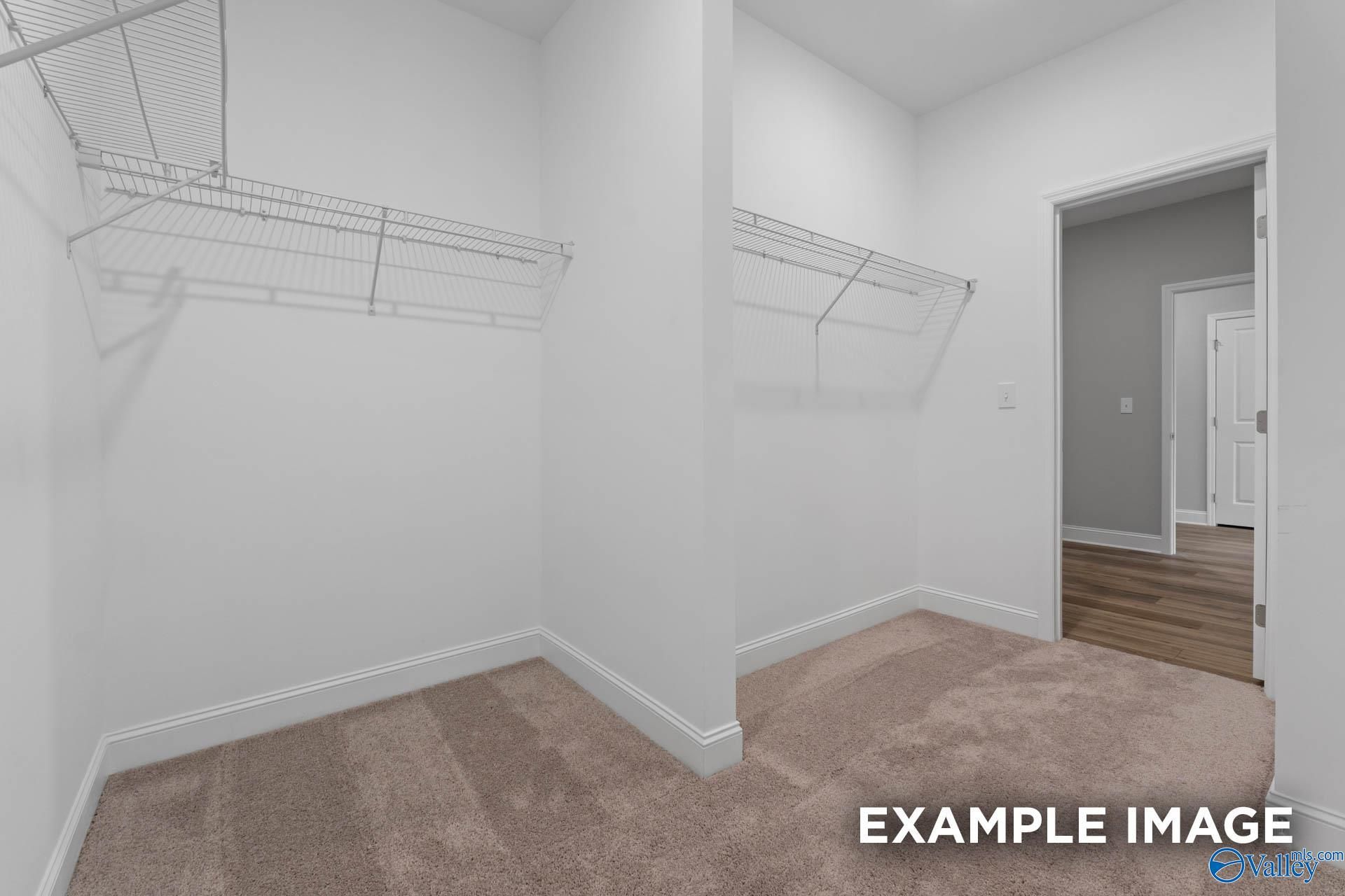 Spacious walk-in closet with wire shelving and hanging rods in master suite of Davidson Homes The Everett, Meridianville, Alabama