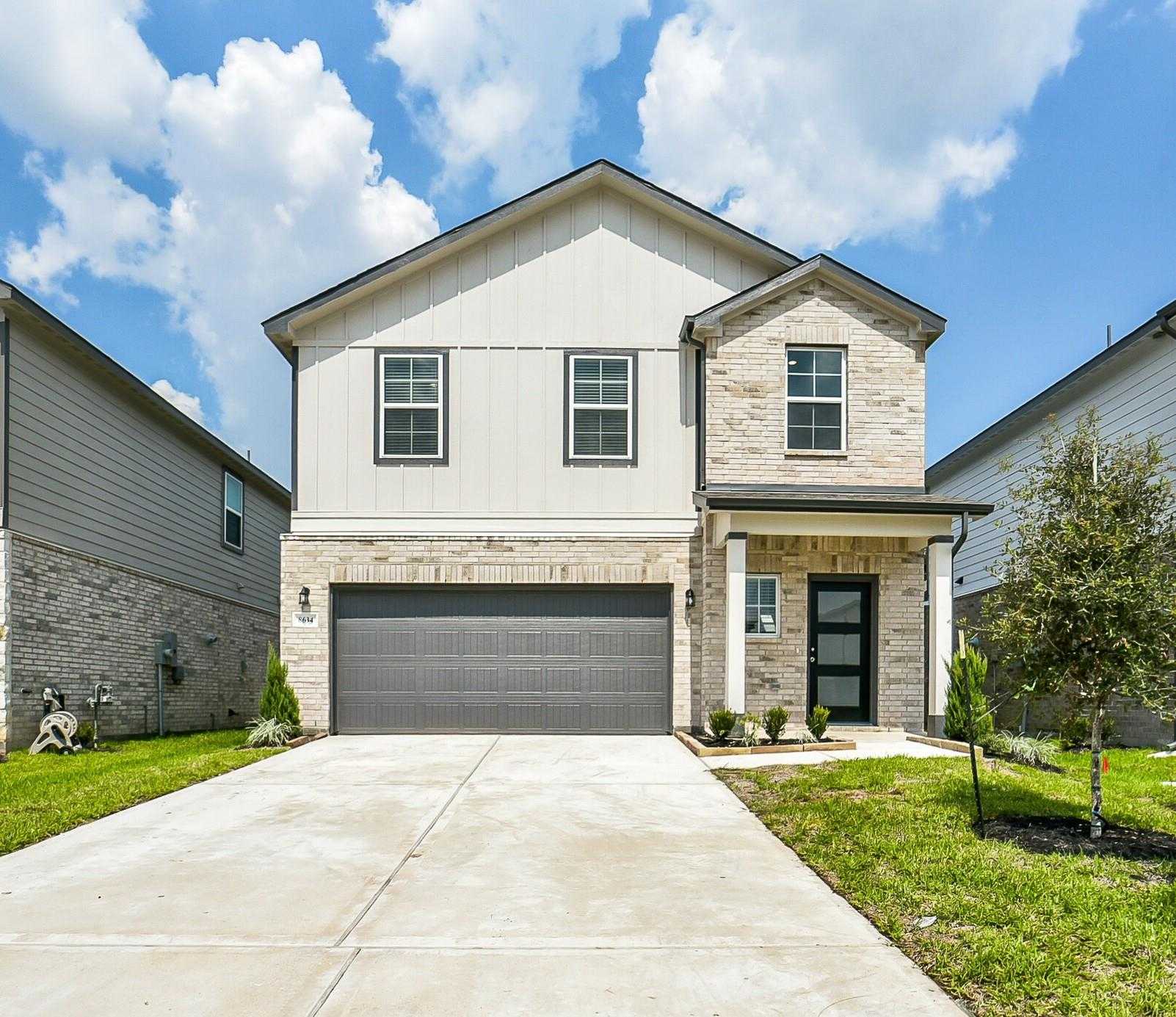 Modern 2-story Davidson Homes Trinity F with brick accents, 2-car garage, and landscaped front yard in Lakes at Black Oak, Magnolia, Texas