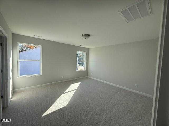 Bright secondary bedroom with light gray walls, carpet floor, and sunny windows in Davidson Homes The Gavin B, Lillington, NC