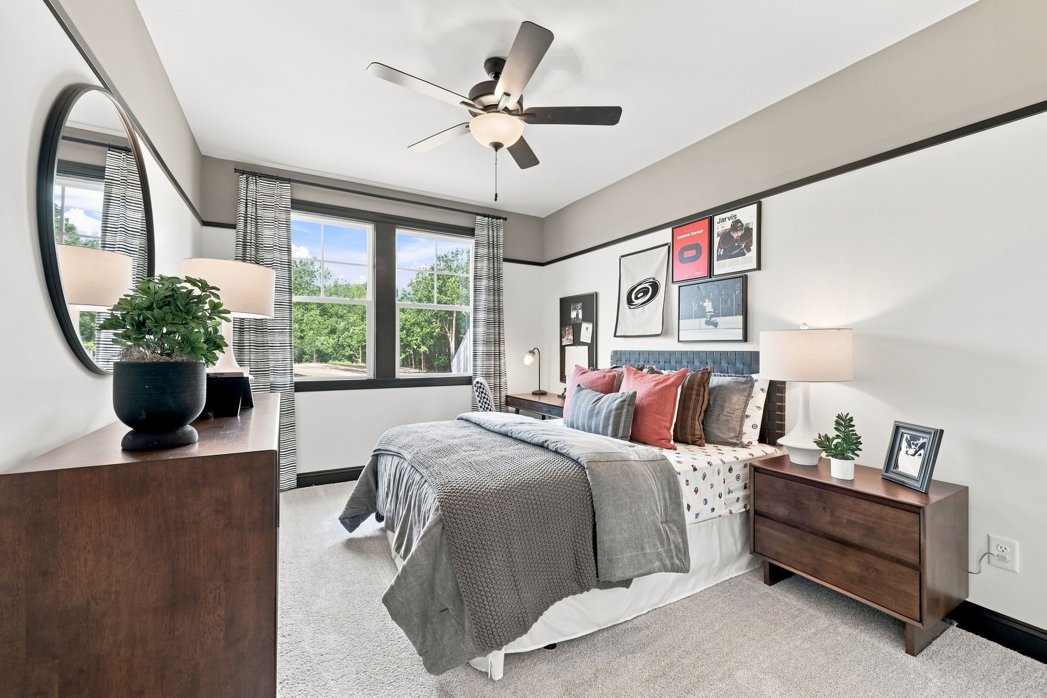 Spacious bedroom in The Barrington C by Davidson Homes featuring modern decor, dark wood furniture, and a comfortable bed.
