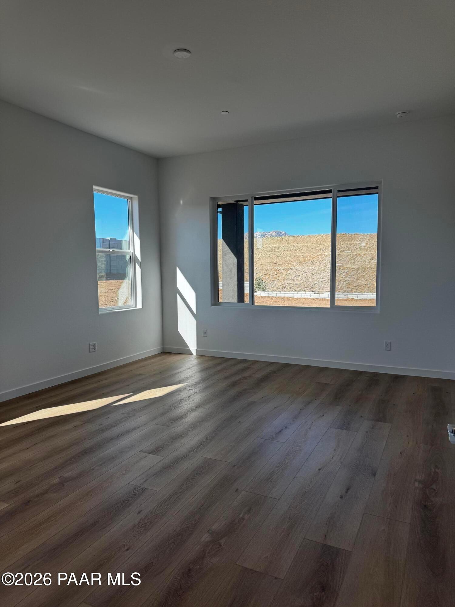 Bright empty great room with large windows overlooking desert landscape in The Blaze C home, Hidden Hills, Prescott, Arizona