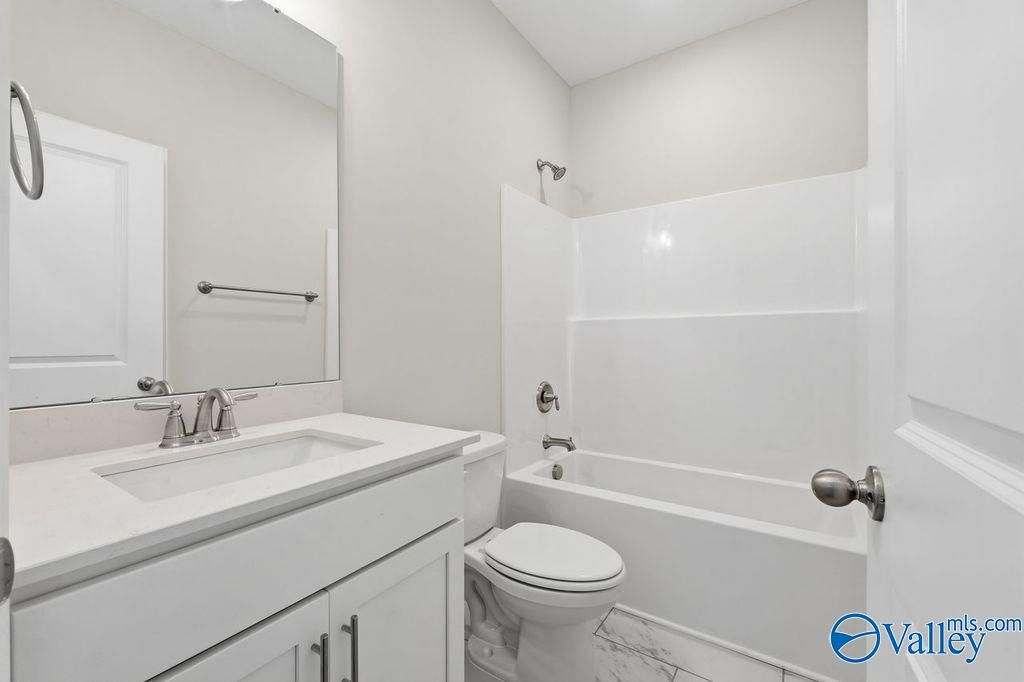 Modern full bathroom with white vanity, tub-shower combo, chrome fixtures, and subway tile in The Harrison, Hartselle Alabama
