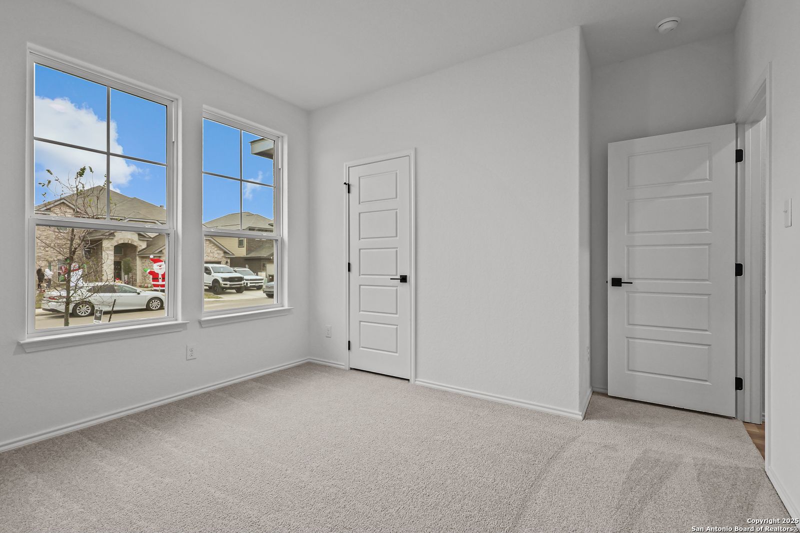 Bright secondary bedroom with large windows and neighborhood view in Davidson Homes The Daphne J, Converse, Texas