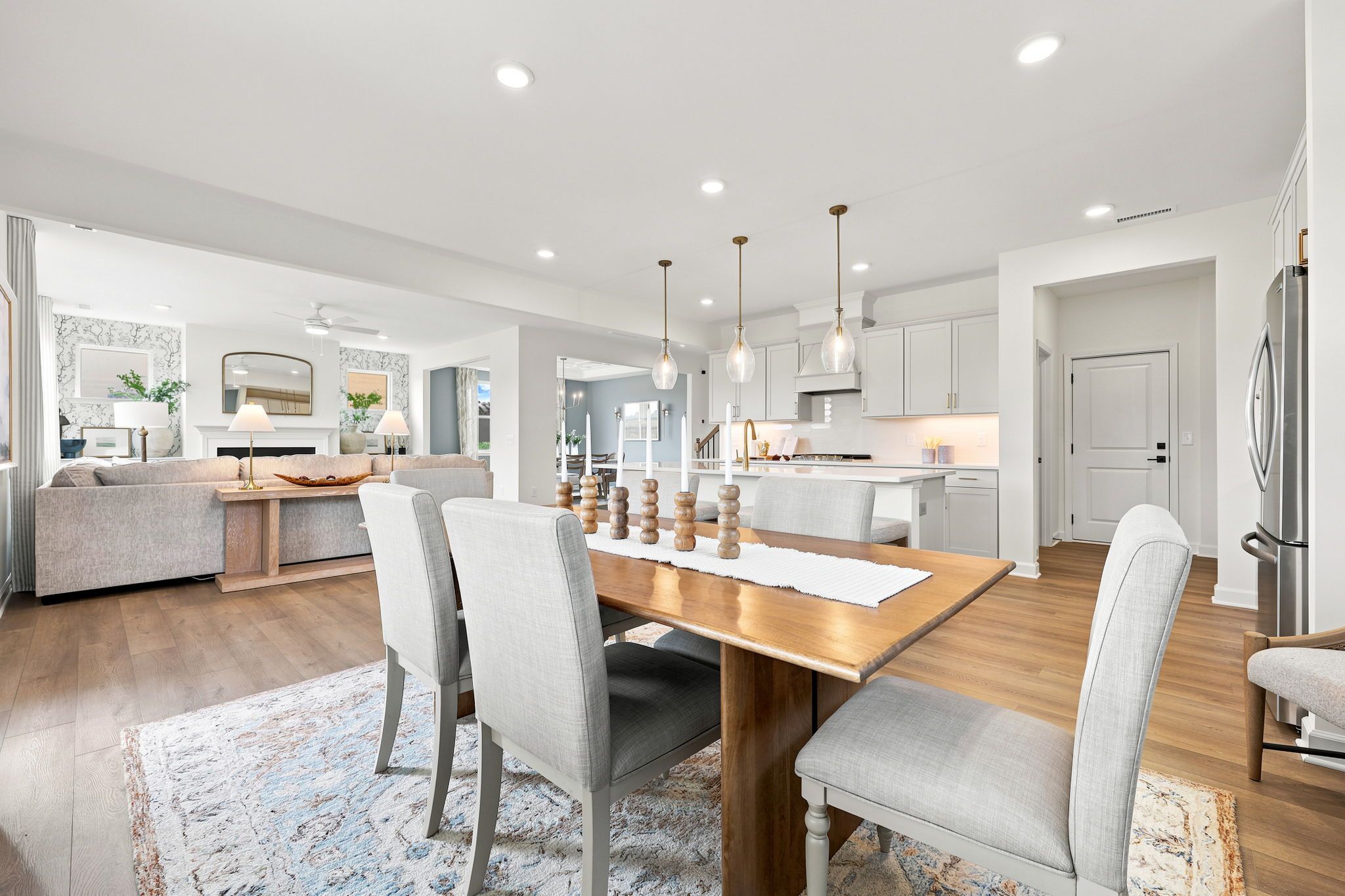 Open-concept dining and living area at Montrose in Aberdeen, NC by Davidson Homes with modern kitchen and hardwood floors.