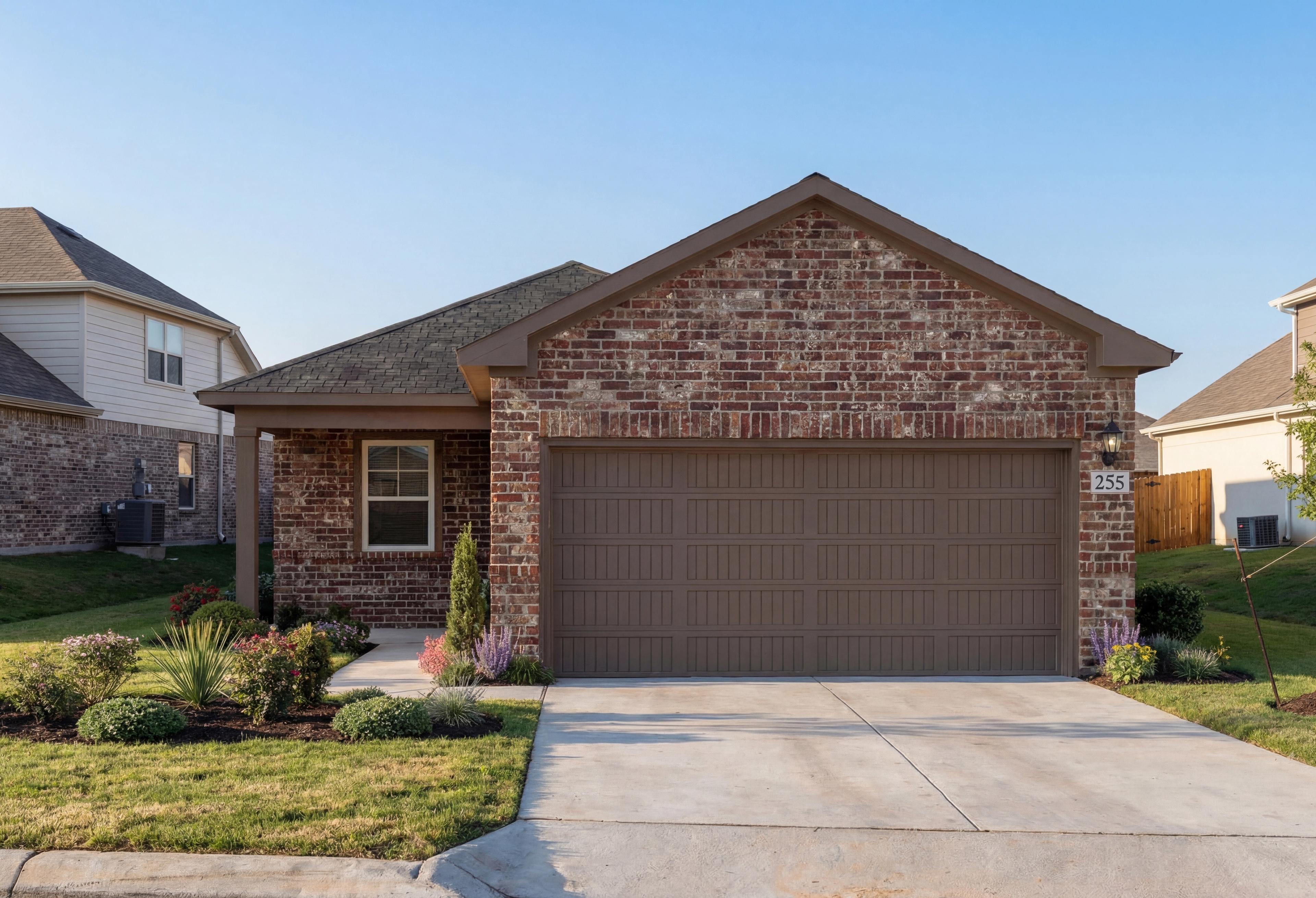Brick exterior of The Comal 1-story home by Davidson Homes, featuring 2-car garage, front porch, and landscaped yard in Magnolia, TX
