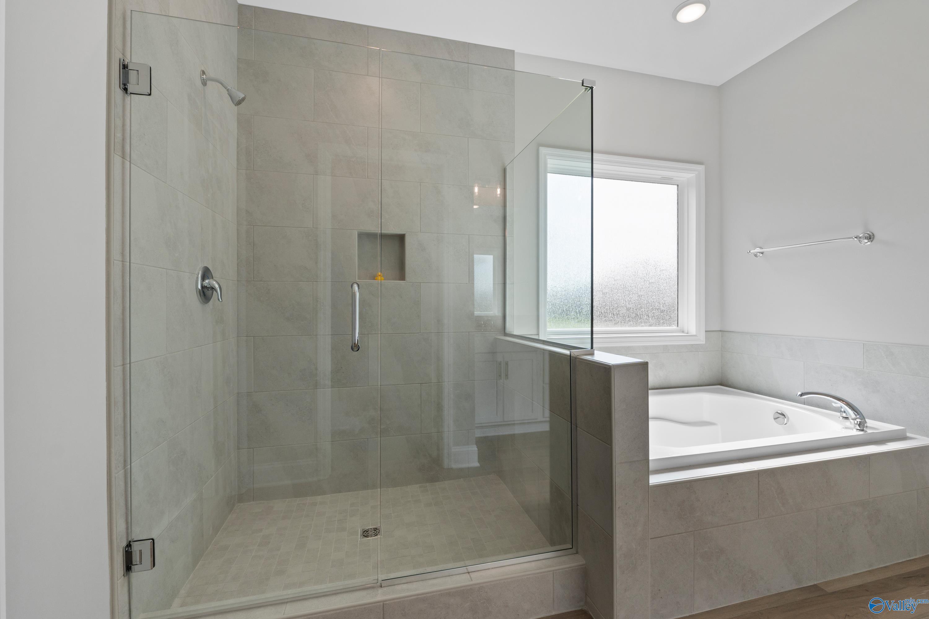 Modern master bathroom featuring glass walk-in shower and freestanding tub in Davidson Homes The Everett B, Toney, Alabama
