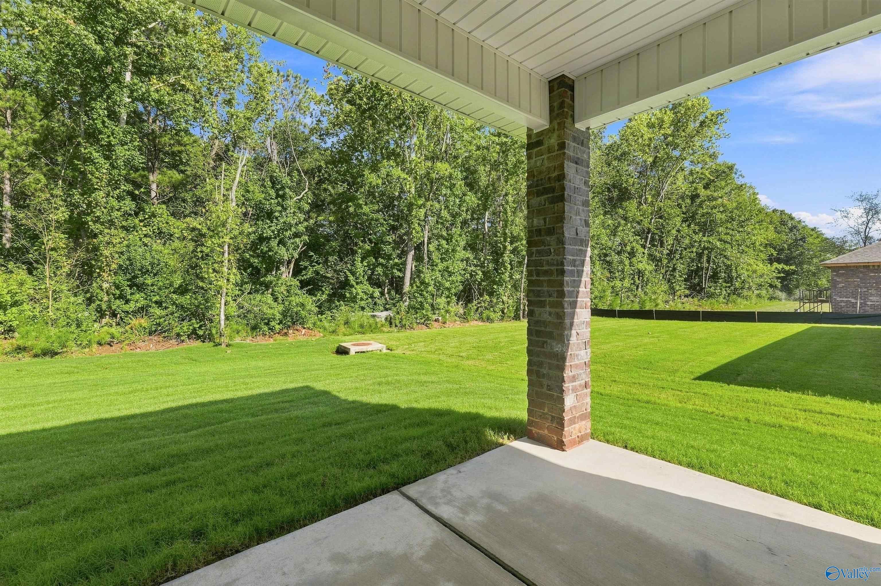 Covered back patio with brick column overlooking private backyard in Spragins Cove, Huntsville, Alabama by Davidson Homes.