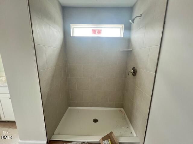 Modern walk-in shower with beige subway tiles, frosted window, and rain showerhead in The Adalynn B master bath, Lillington, NC