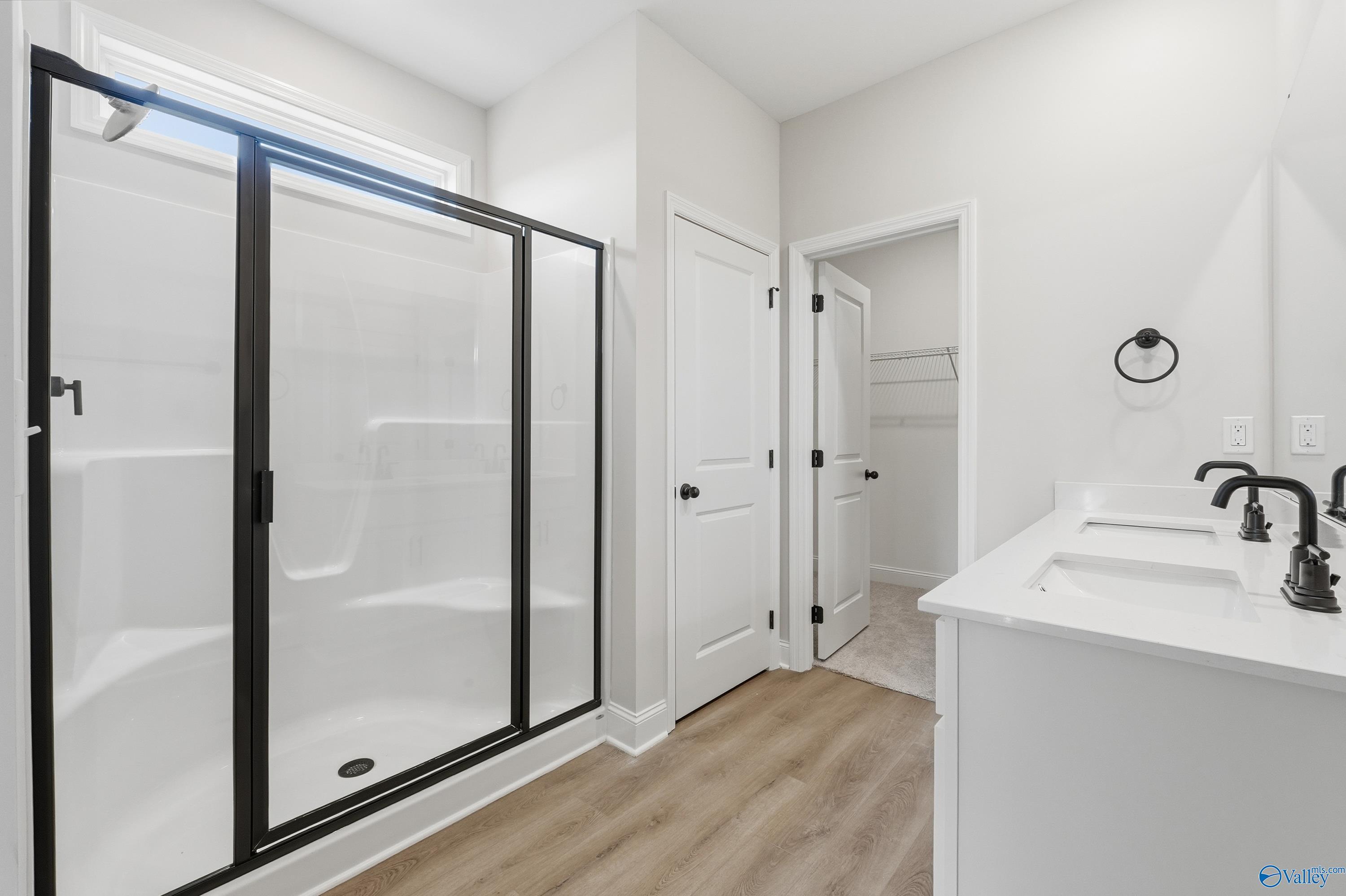 Modern master bathroom featuring frameless glass shower and double vanity in Davidson Homes The Franklin E, Hazel Green, Alabama