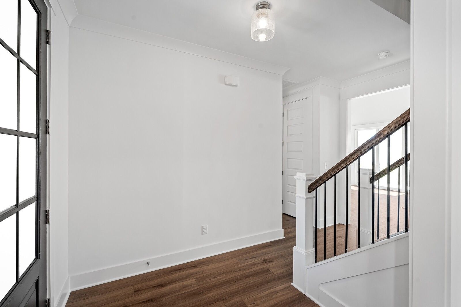 Bright foyer with hardwood floors and modern black metal staircase in The Hawkins 4-bedroom home, Murfreesboro, TN