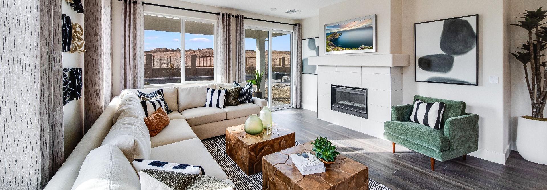 Spacious living room in South Ranch Western Collection, Prescott AZ with white sectional sofa, wood coffee table, fireplace, and large sliding doors