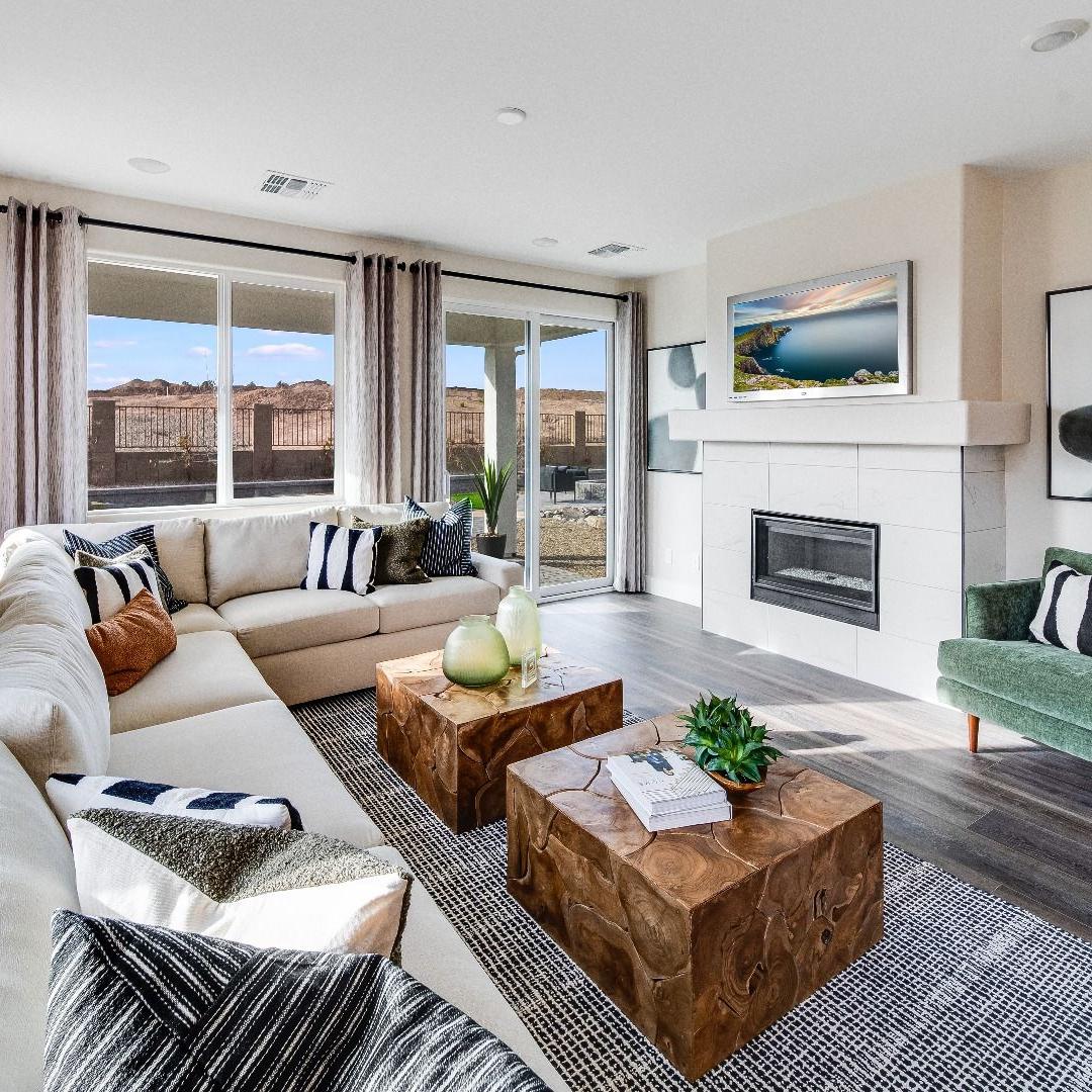 Spacious living room in South Ranch Western Collection, Prescott AZ with white sectional sofa, wood coffee table, fireplace, and large sliding doors