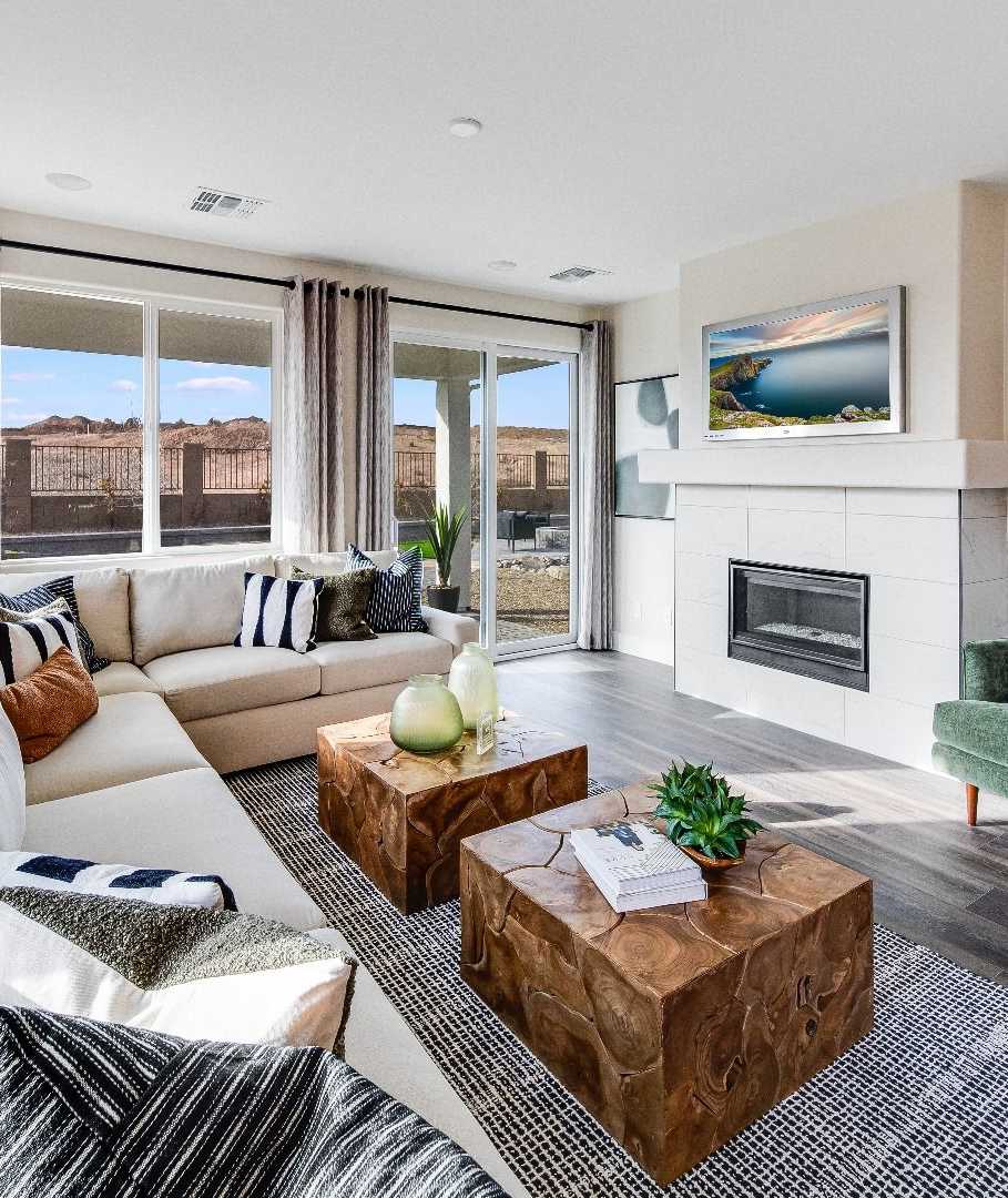 Spacious living room in South Ranch Western Collection, Prescott AZ with white sectional sofa, wood coffee table, fireplace, and large sliding doors